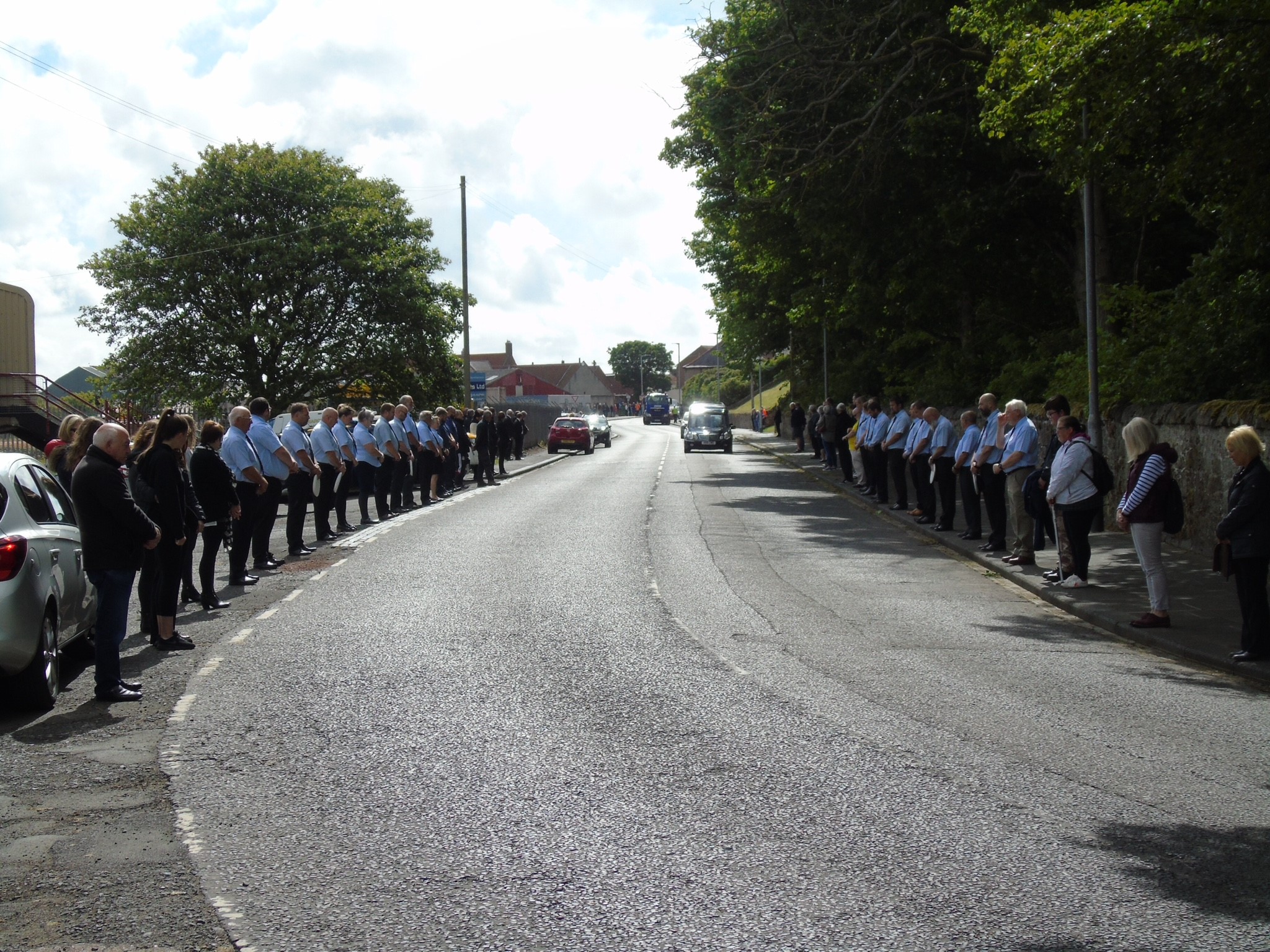 Crew line the street to say farewell to former crewman Douglas Blackhall as his hearse passes the lifeboat station.