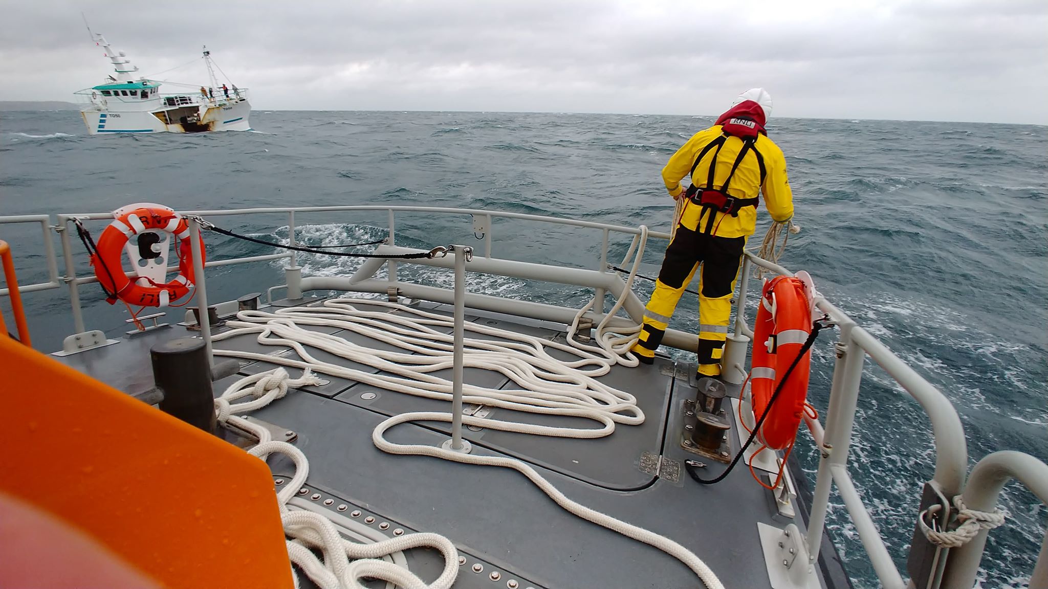 Volunteer crew member prepares to pass the tow to the casualty vessel.