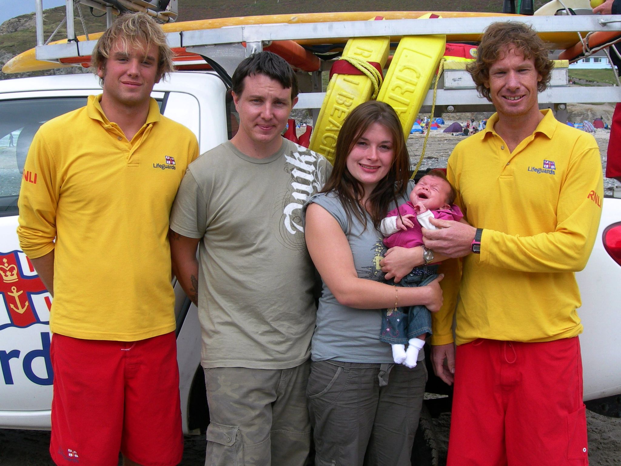 Vicky Murphy holds her baby daughter Rae with her husband and two lifeguards beside her
