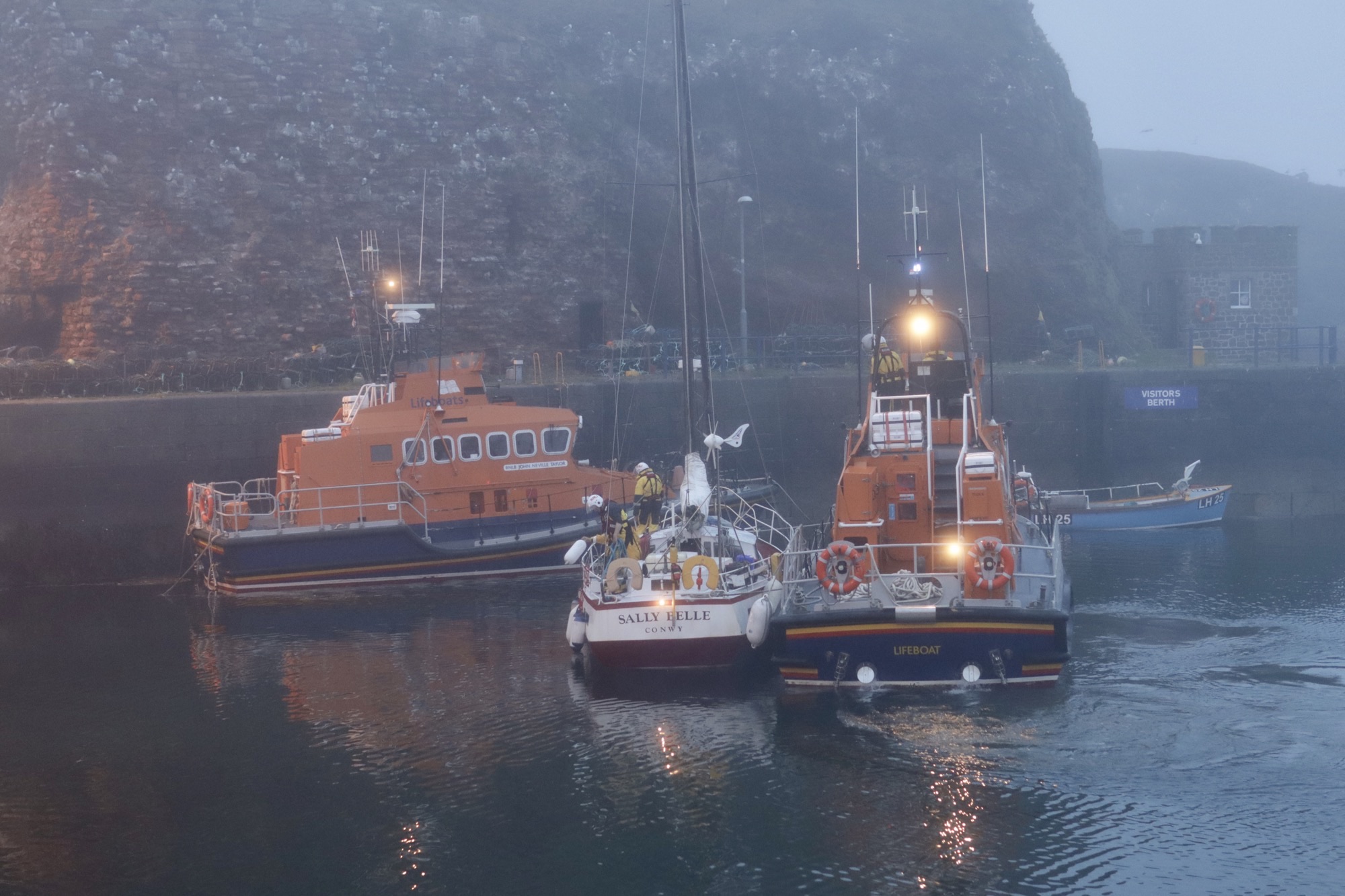 The crew prepare to moor the yacht alongside the John Neville Taylor lifeboat.