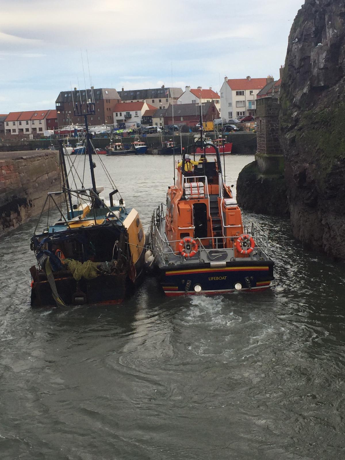 Photo shows Dunbar all-weather lifeboat with the Spitfire fishing boat on an alongside tow coming into Dunbar Harbour.