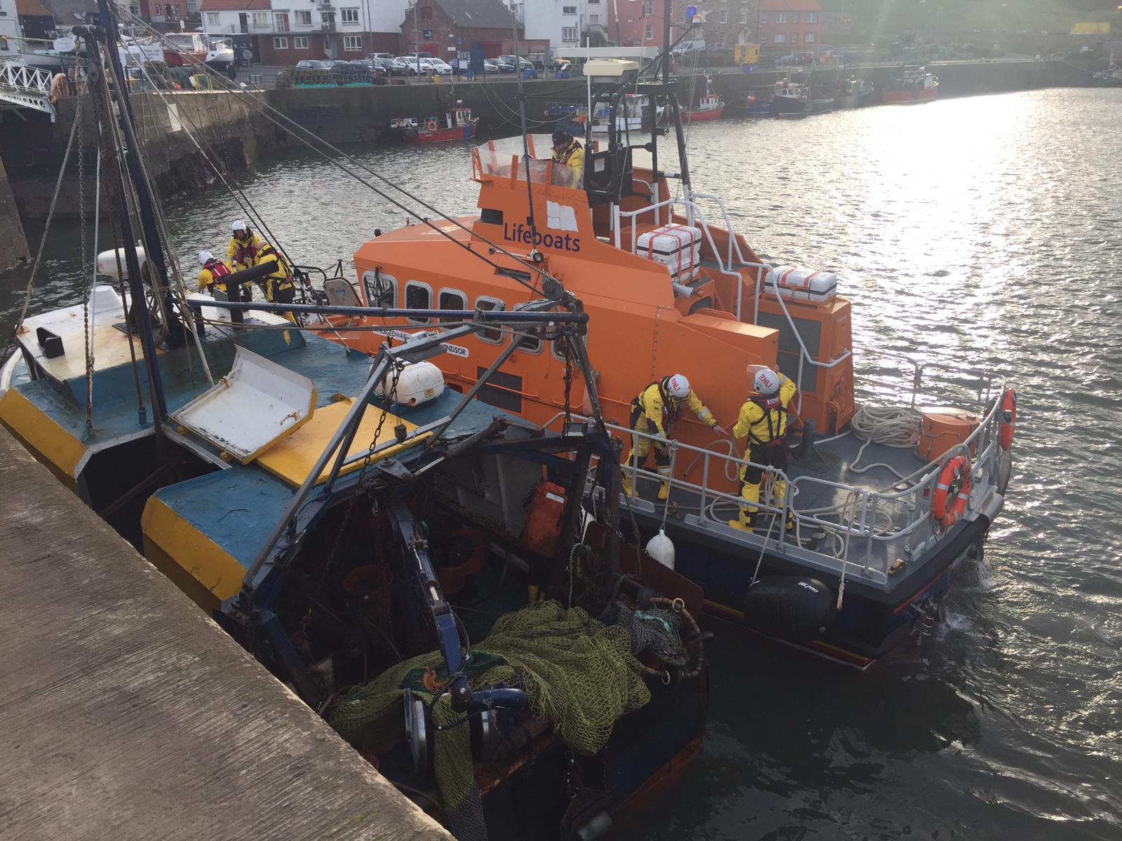 Dunbar all-weather lifeboat brings the tail-tied fishing boat to a safe berth in Dunbar Harbour.