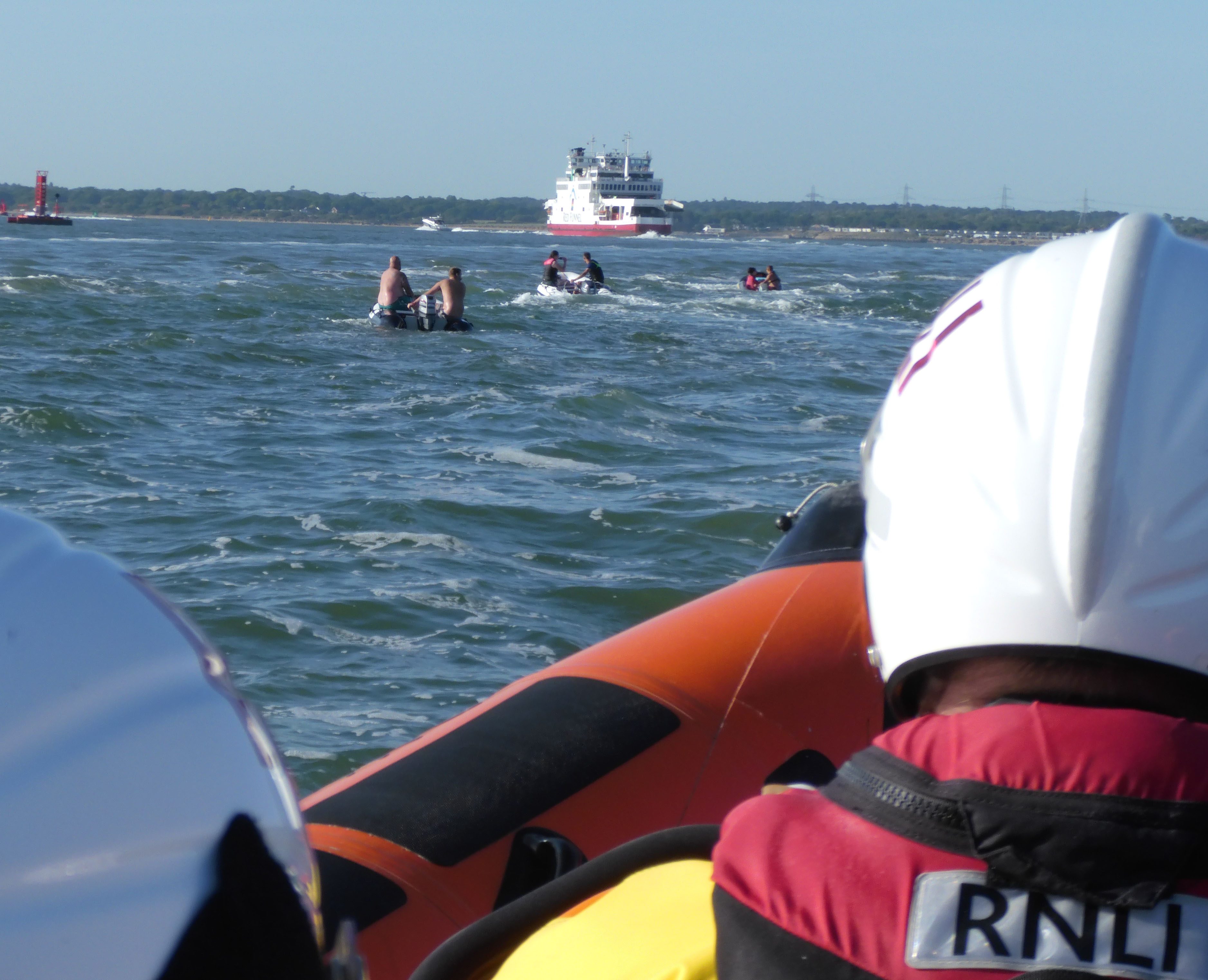With Cowes lifeboat in the foreground, some of the small boats are pictured crossing back to the mainland, passing a RedFunnel car ferry on the way.