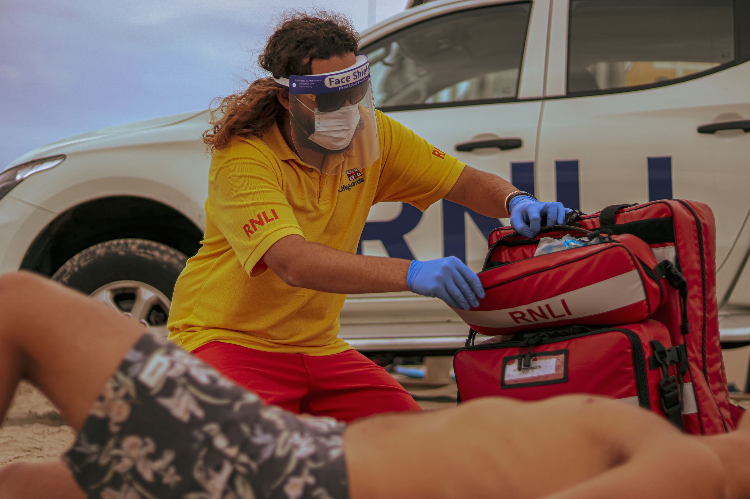 Lifeguard attending to casualty on beach