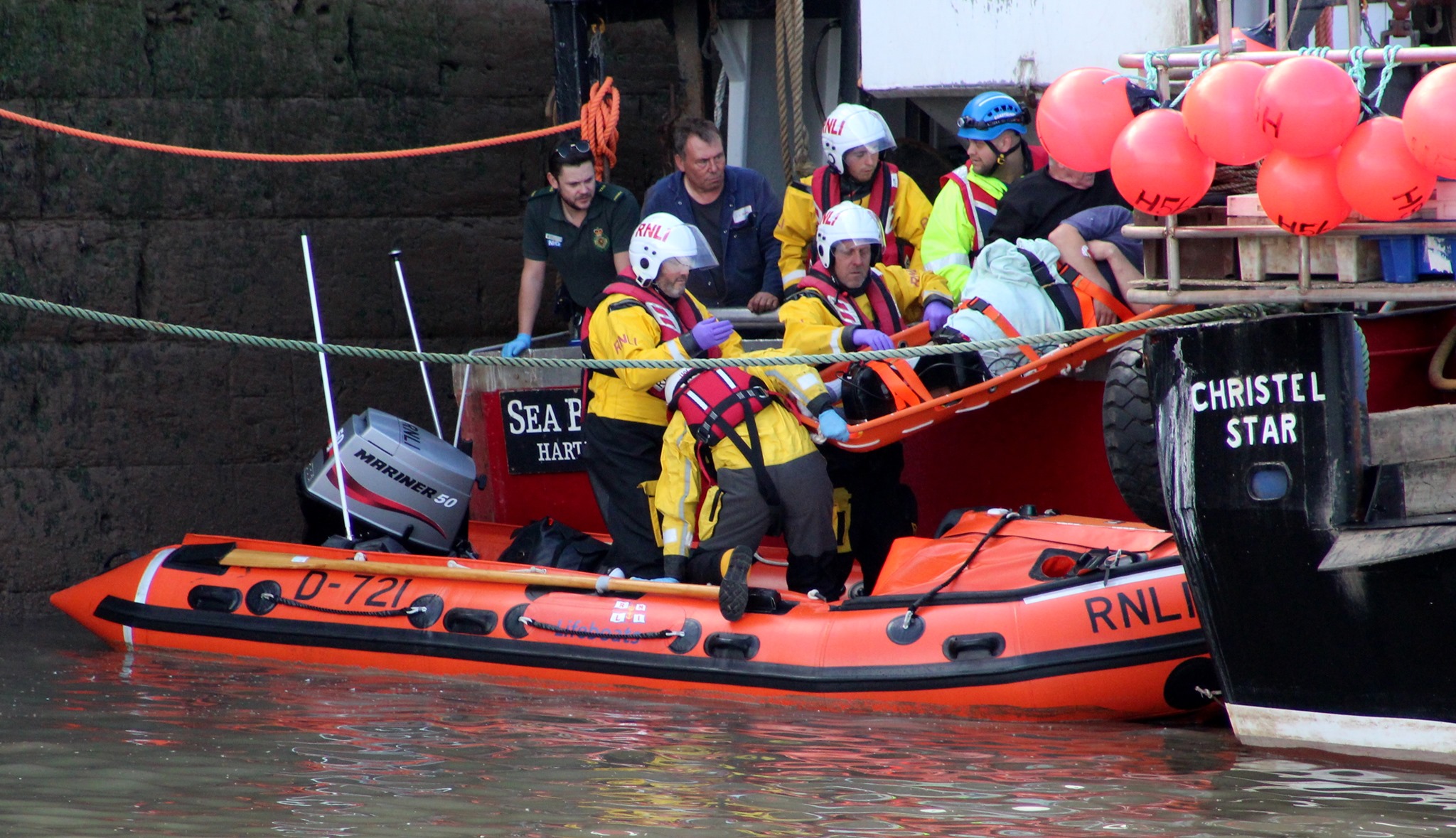 The inshore lifeboat crew life a casualty onto the harbour
