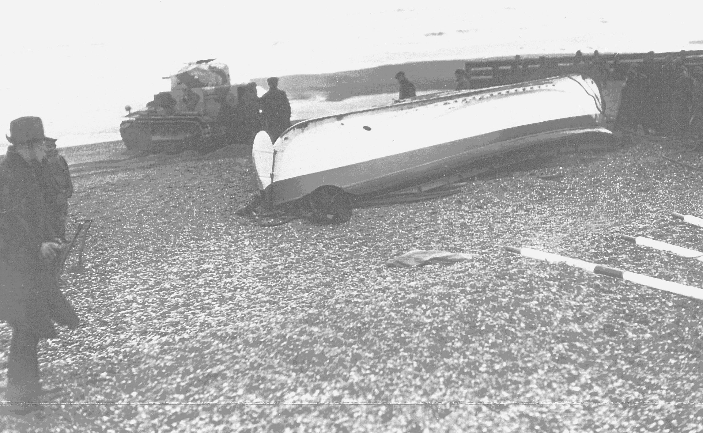 The Mary Stanford lifeboat upside down on Camber beach, In the background is a tank used to turn her over.