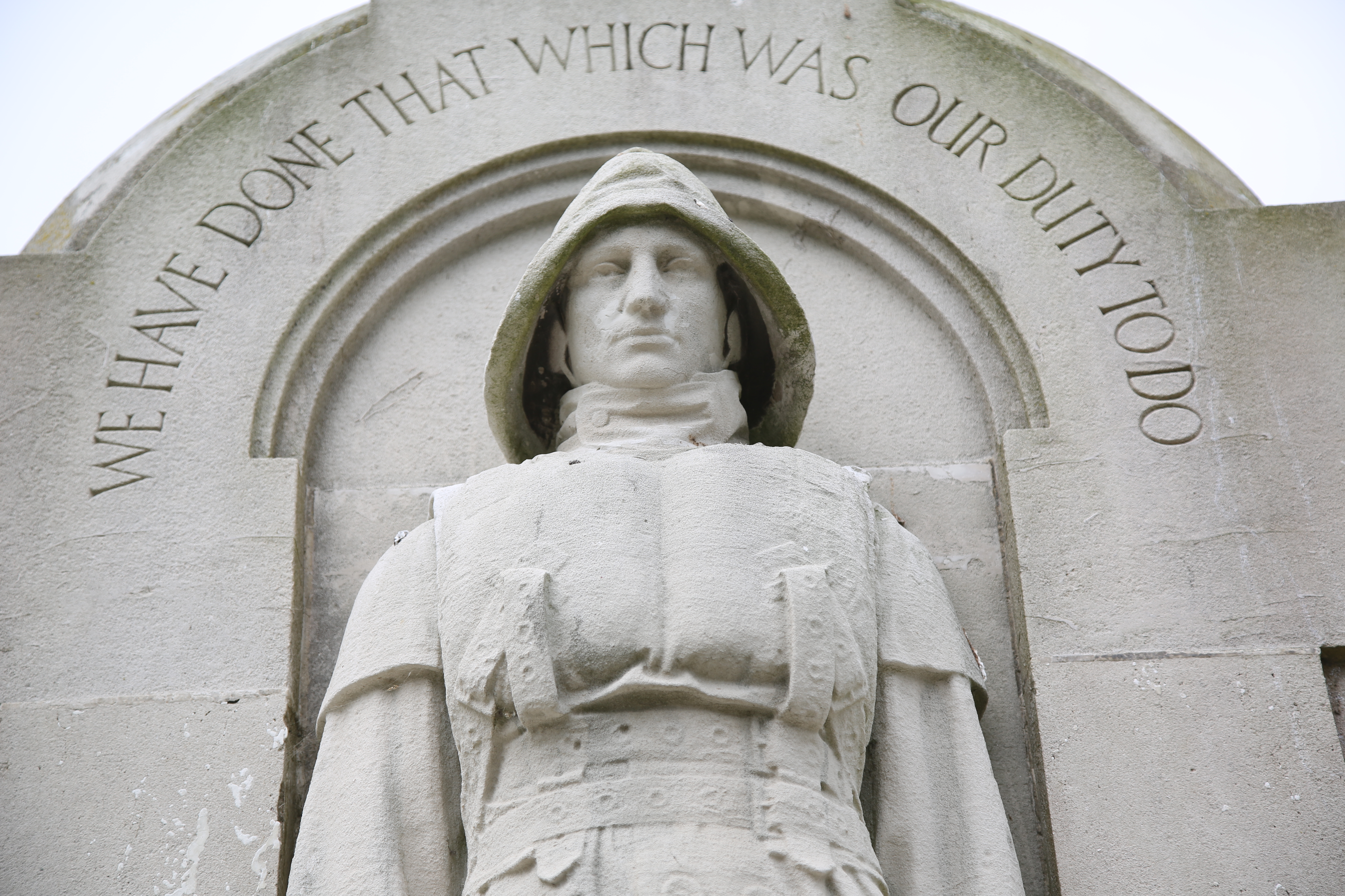 The stone statue of a lifeboat crewman on the memorial to the Mary Stanford in the churhchyard of Rye Harbour