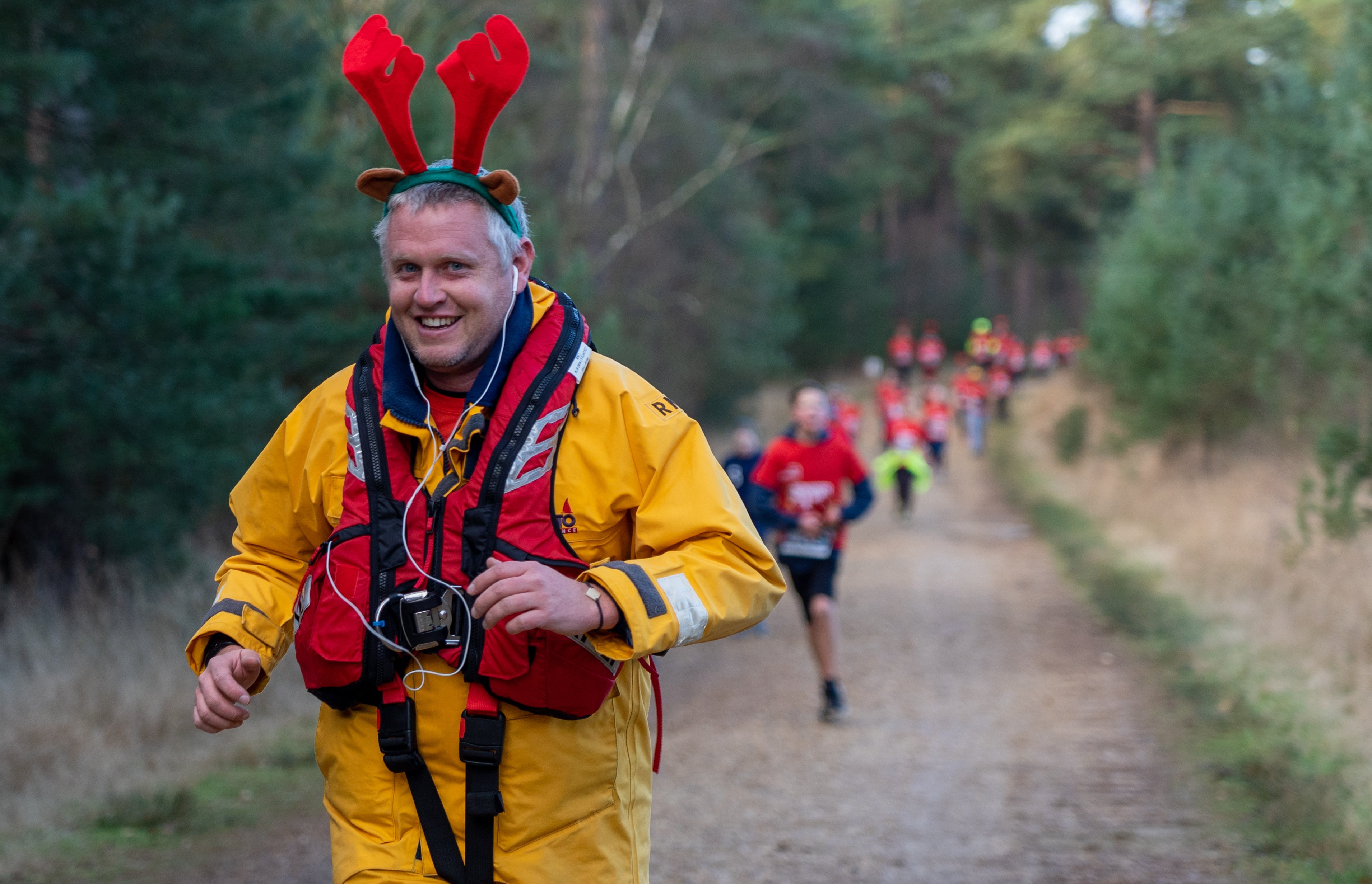 Photo of RNLI crew member running in full kit and antlers from a previous year's event.