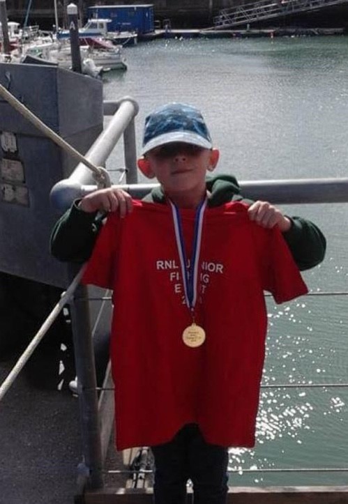 Riley pictured in 2019 with his medal and tee shirt after taking part in the annual junior fishing competition.
