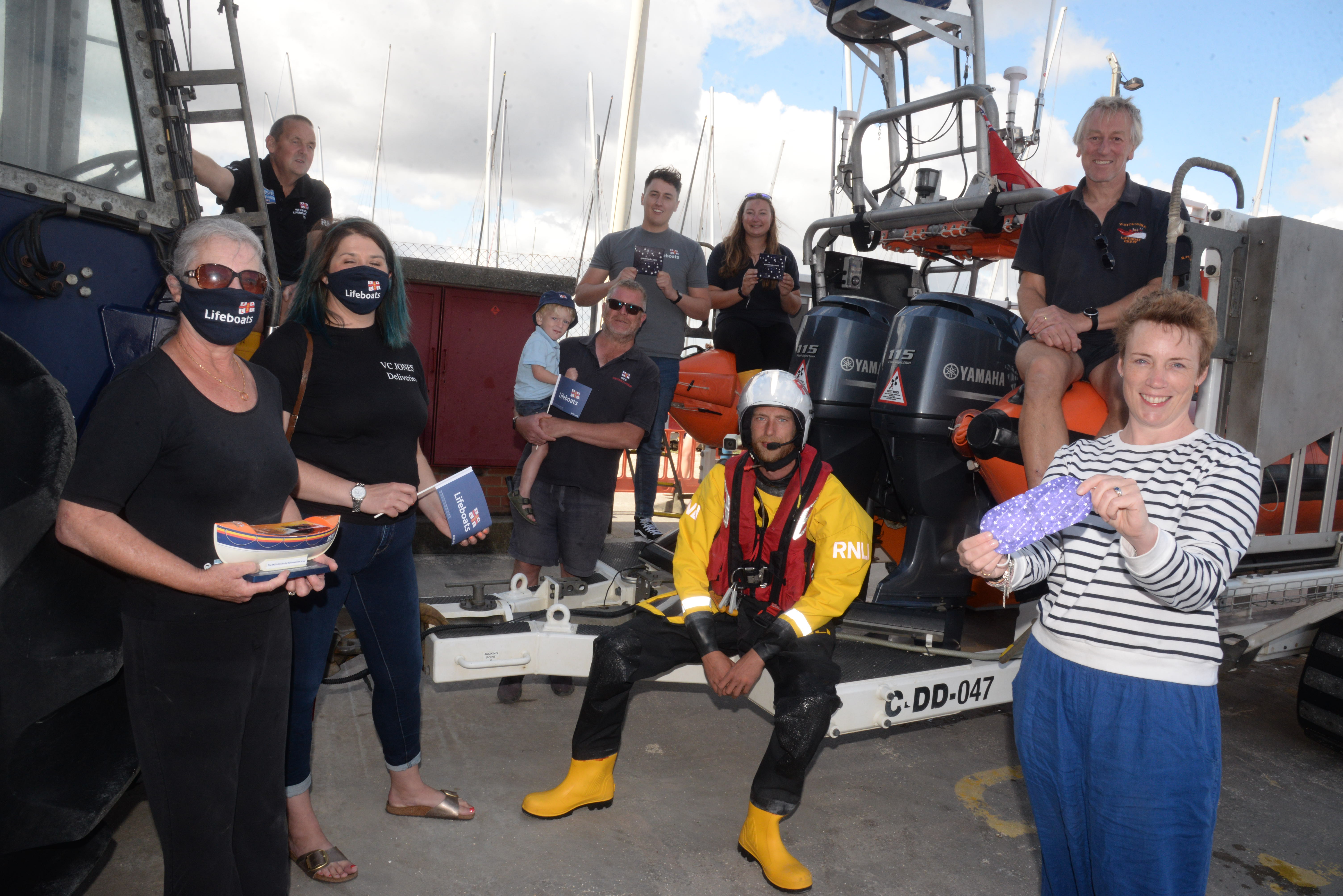Madeleine Jones and Heather Scott of V.C. Jones with Harriet Inglis of Spacemasks with members of the Whitstable lifeboat station on Sunday.