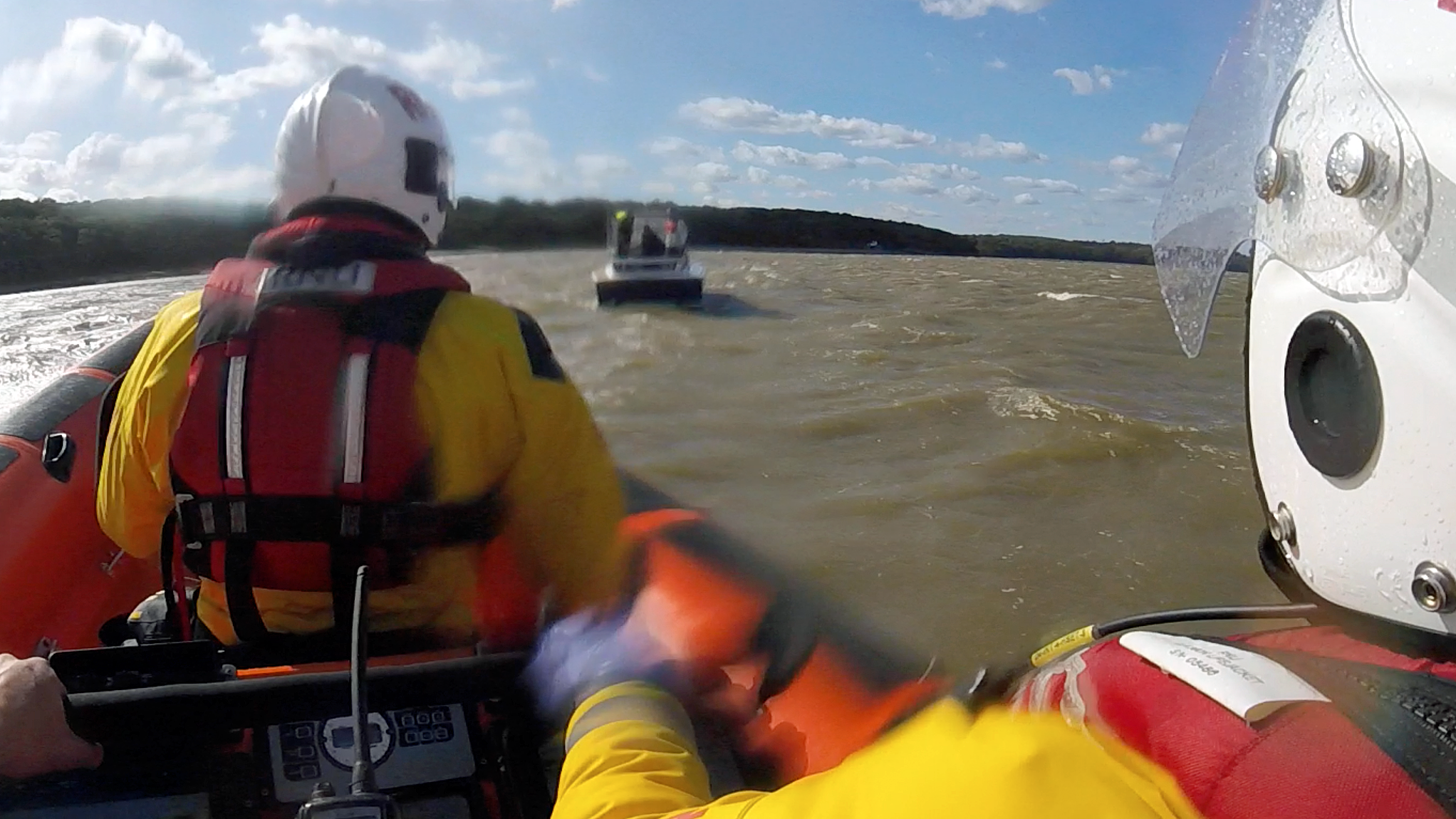Two members of the lifeboat crew pictured as their craft approaches the stricken motorboat.