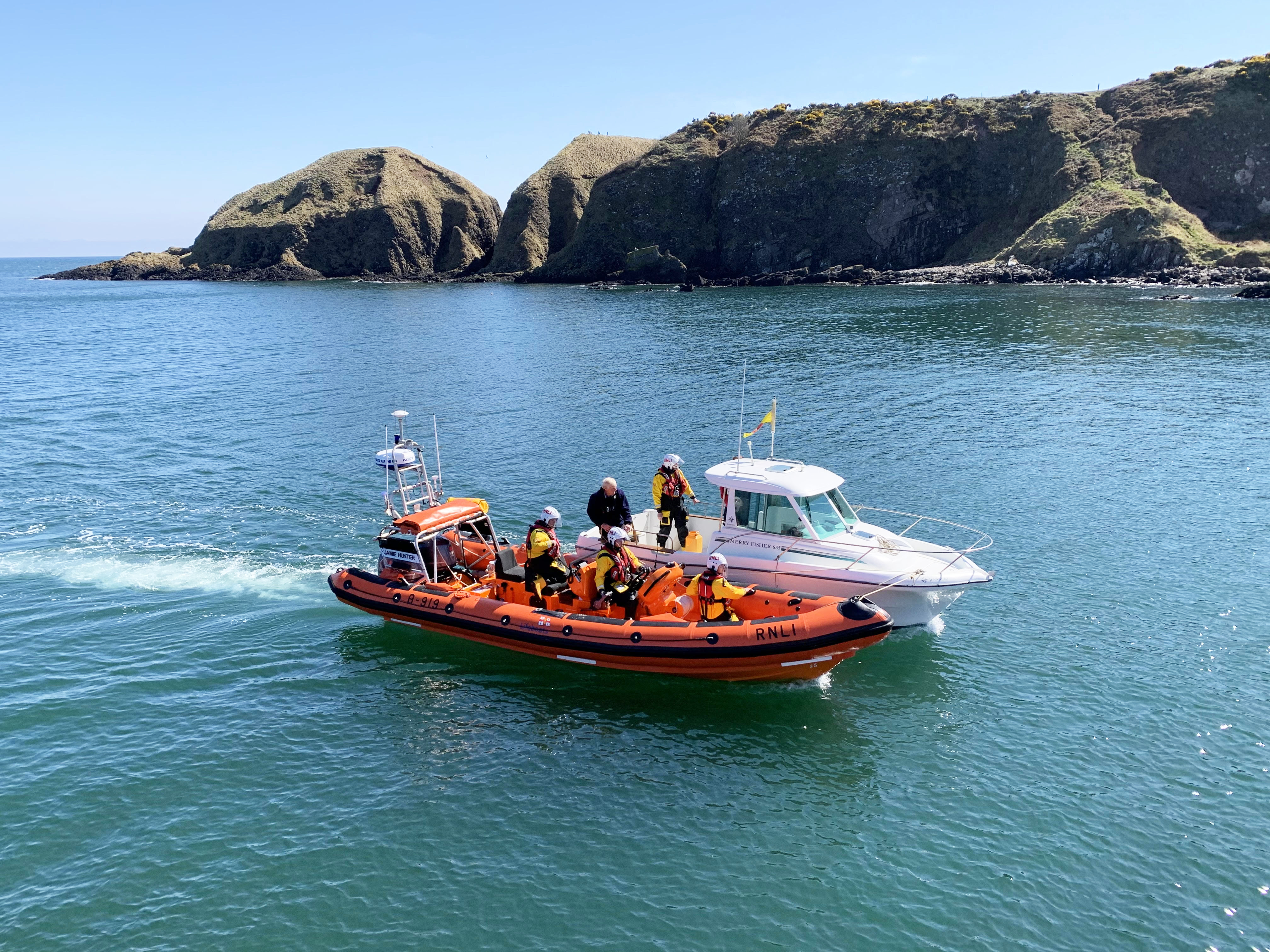 The volunteer crew on the Jamie Hunter escort the Woodstock into Stonehaven harbour