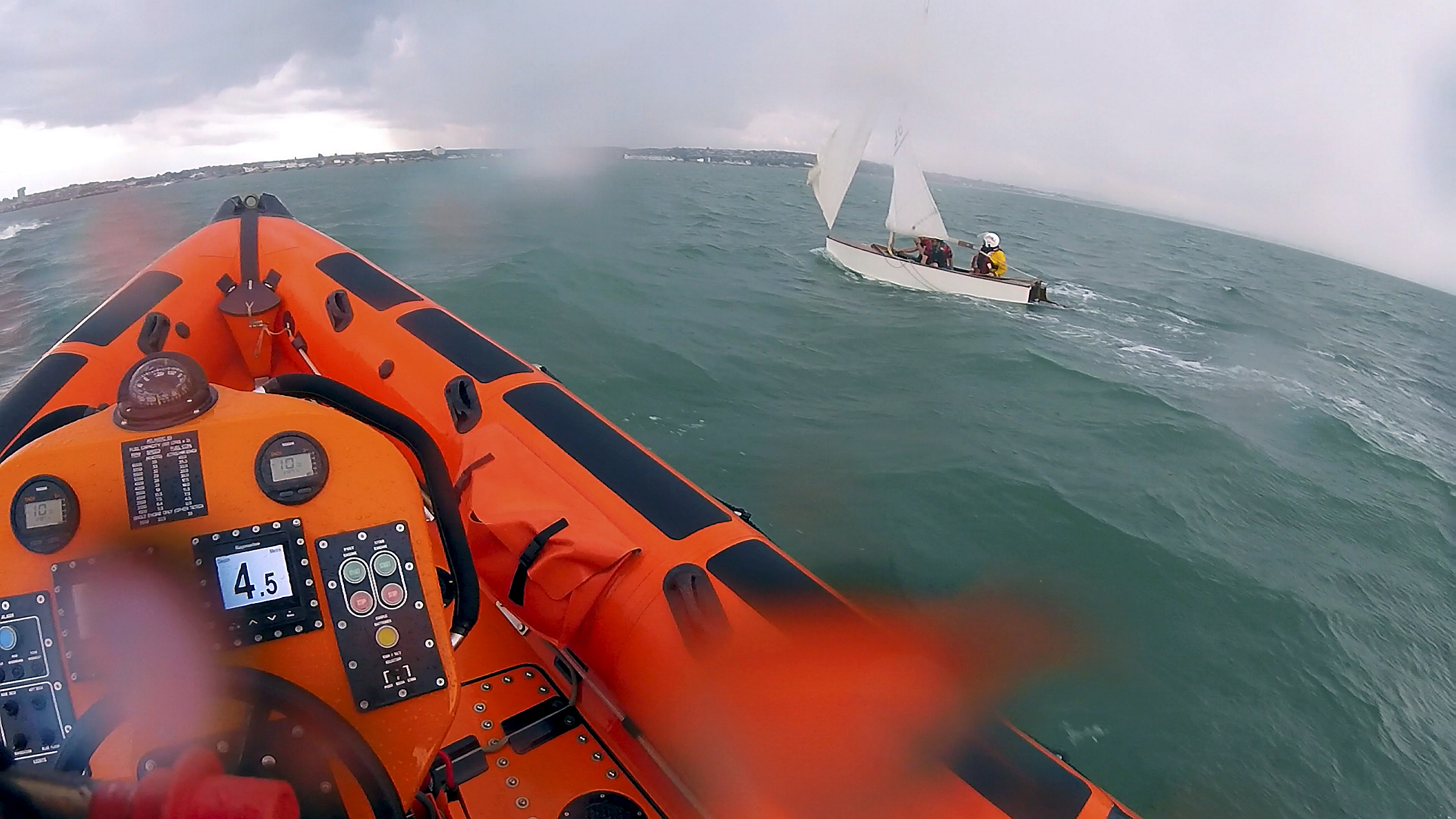 Lifeboat crew member Ruth Oliver assists the occupants of the sailing dinghy in returning to shore on Saturday afternoon.