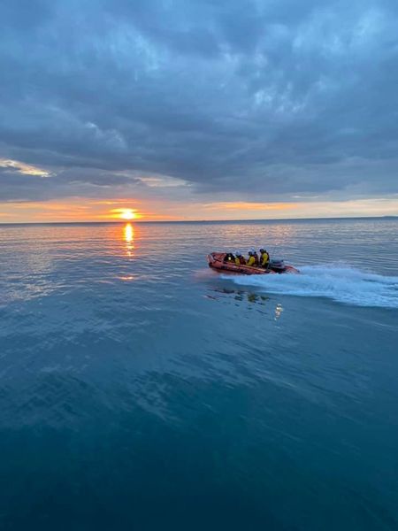 Inshore lifeboat on clam sea with sun setting