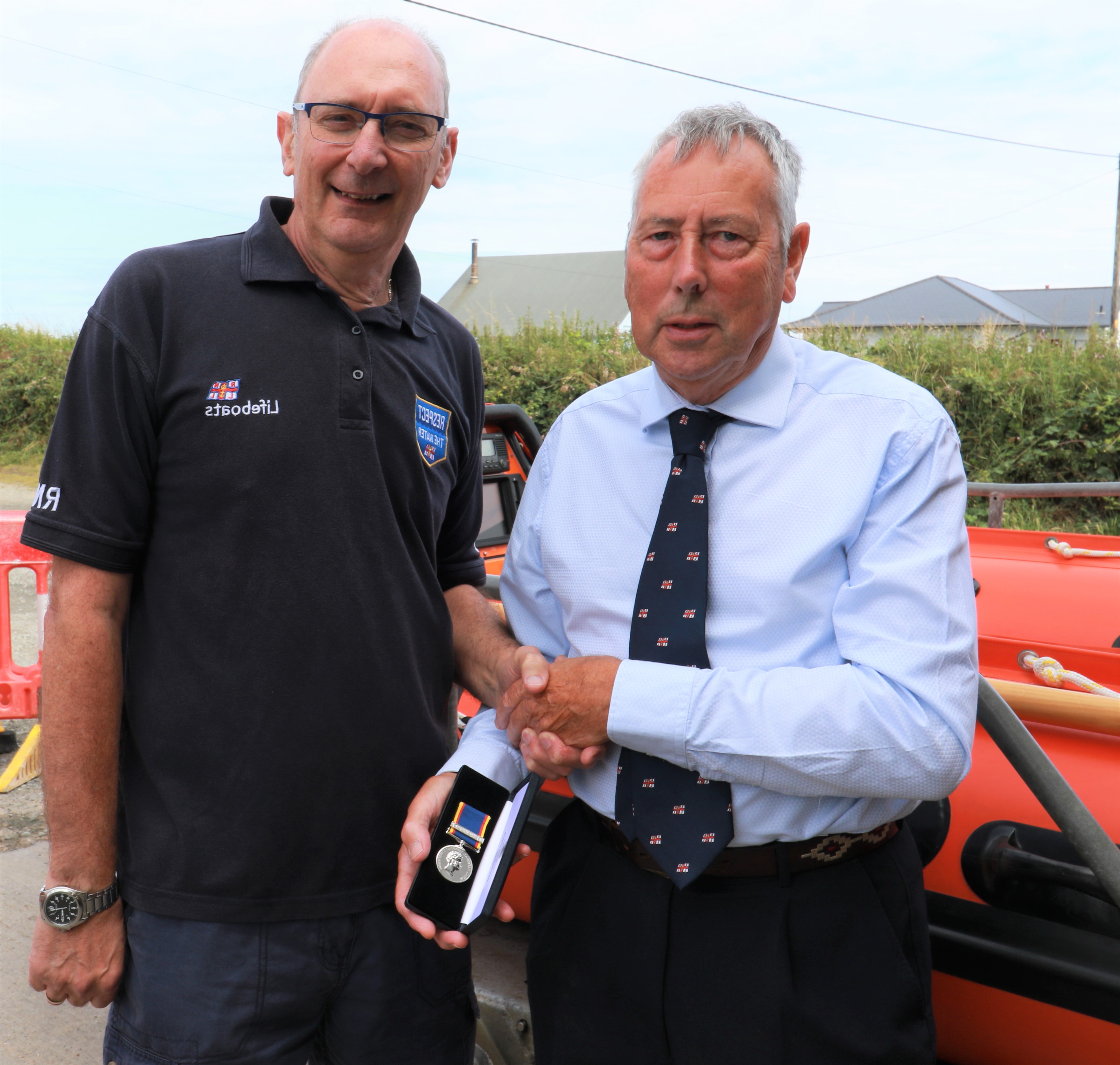 Philip Smith handing Cedric Cox his Fifty year long service medal