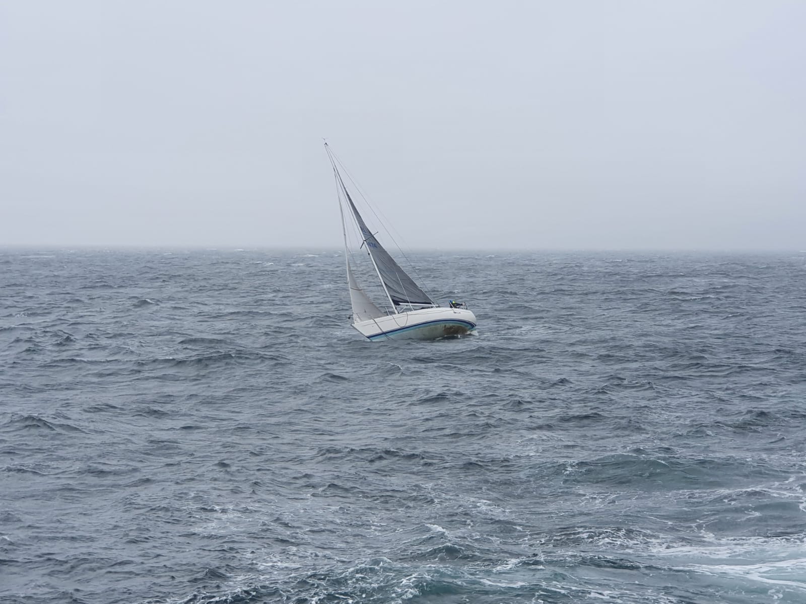 Troubled yacht in the distance in water