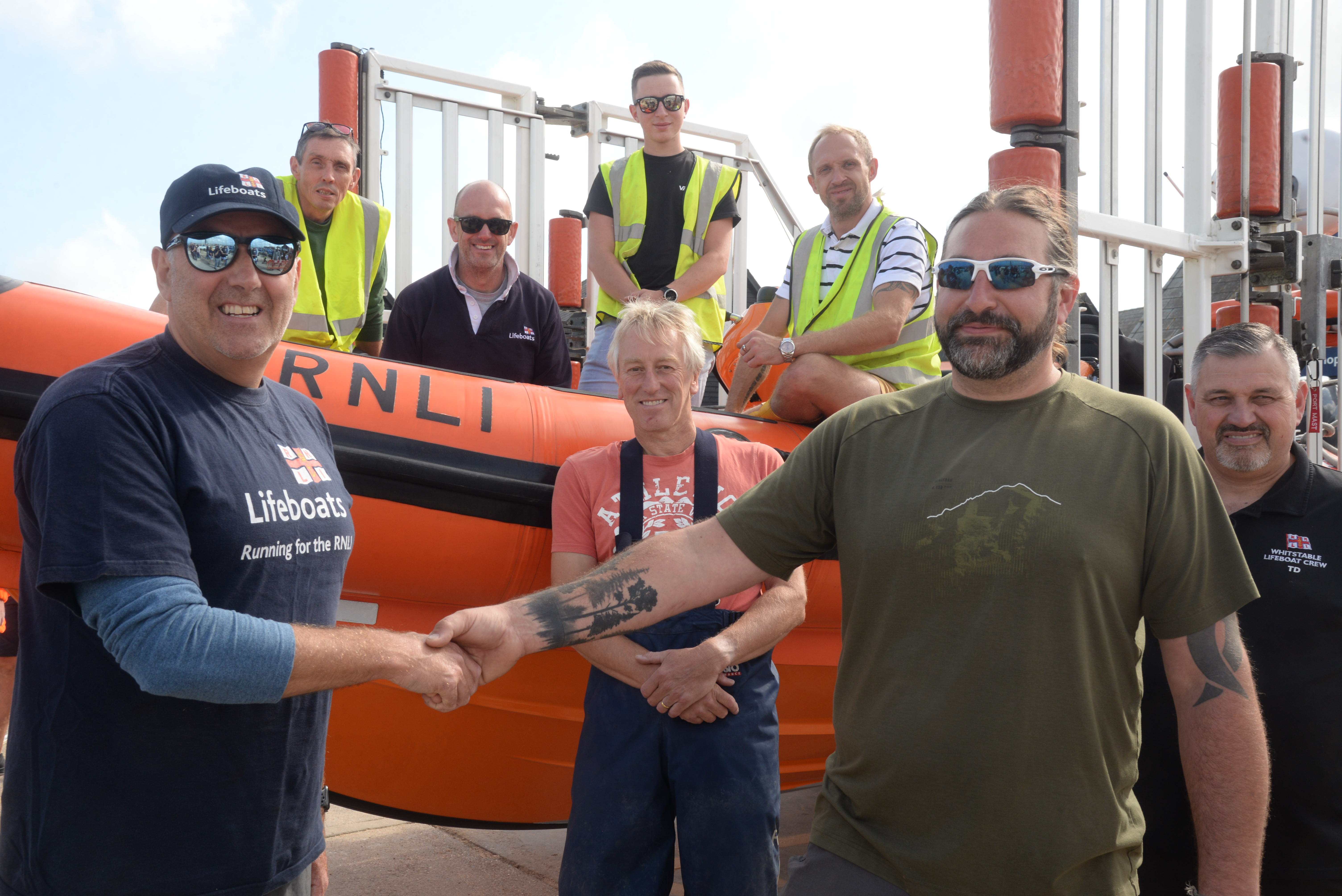 Andy Mayo, Whitstable Lifeboat Community Sea Safety Officer thanks Toby Corall for his fund raising effort in making the glass topped driftwood table which sold for £600.