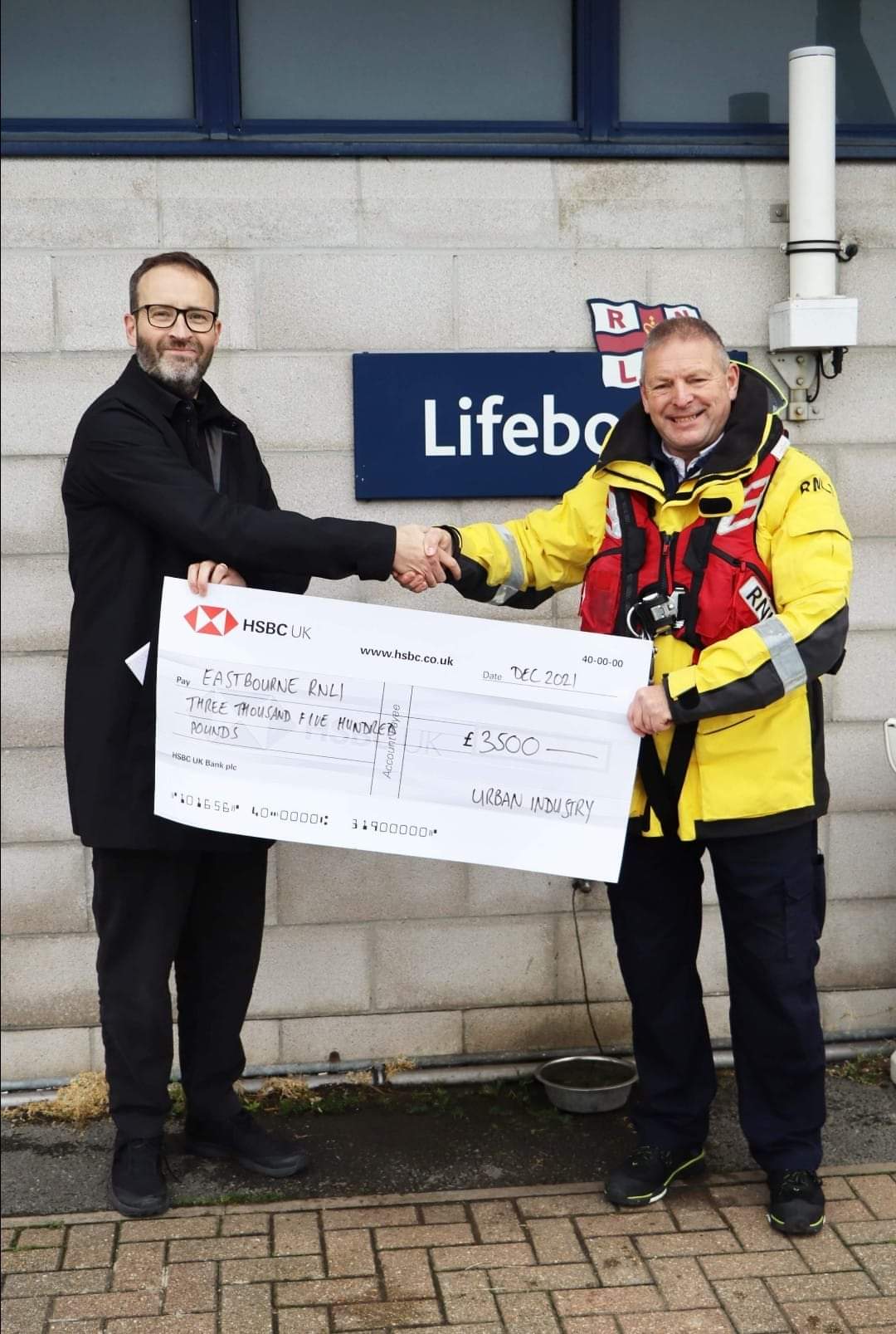 Eastbourne Coxswain Mark Sawyer accepting cheque from Mr King