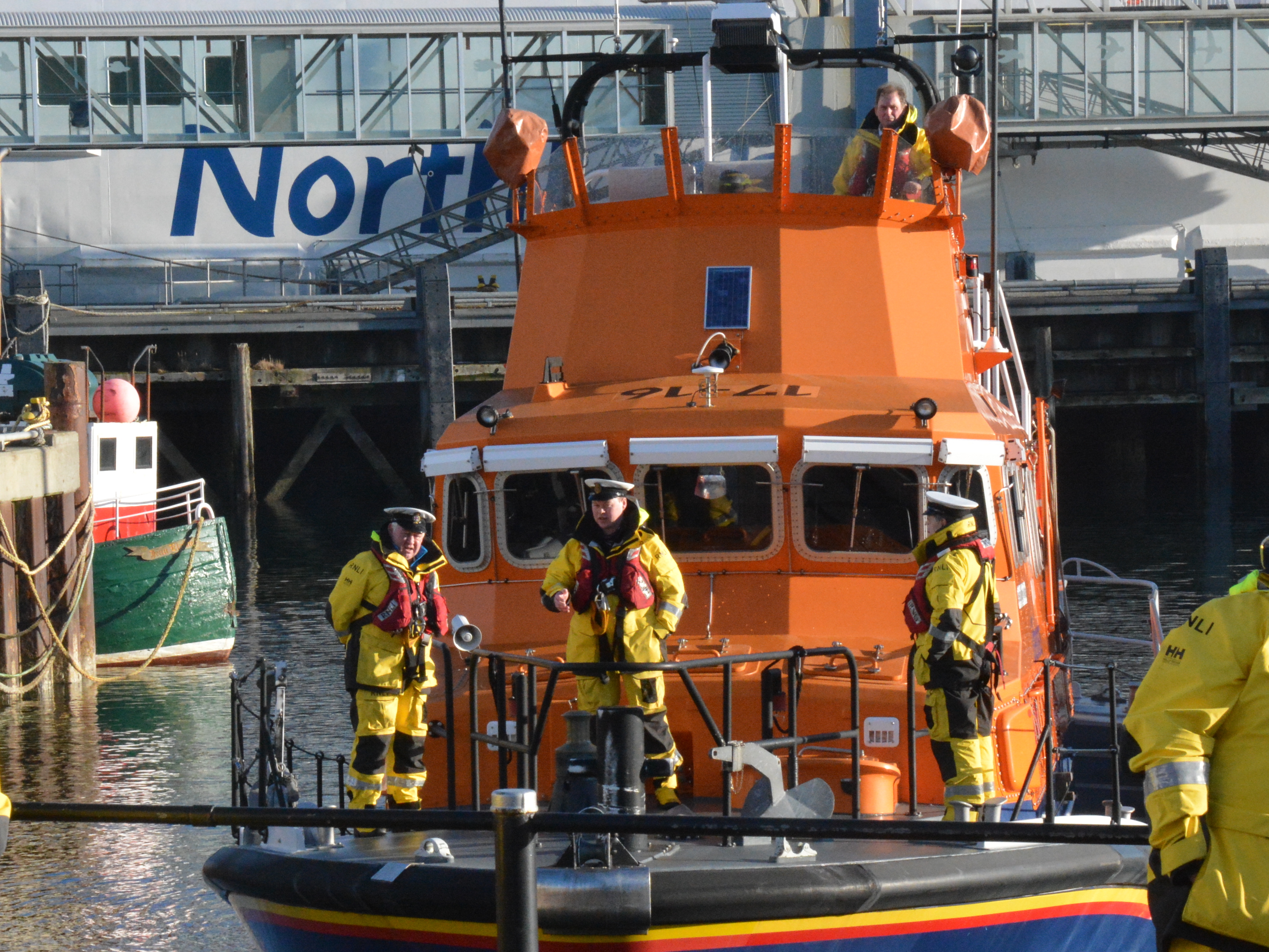 Crew in uniform caps on prow of lifeboat