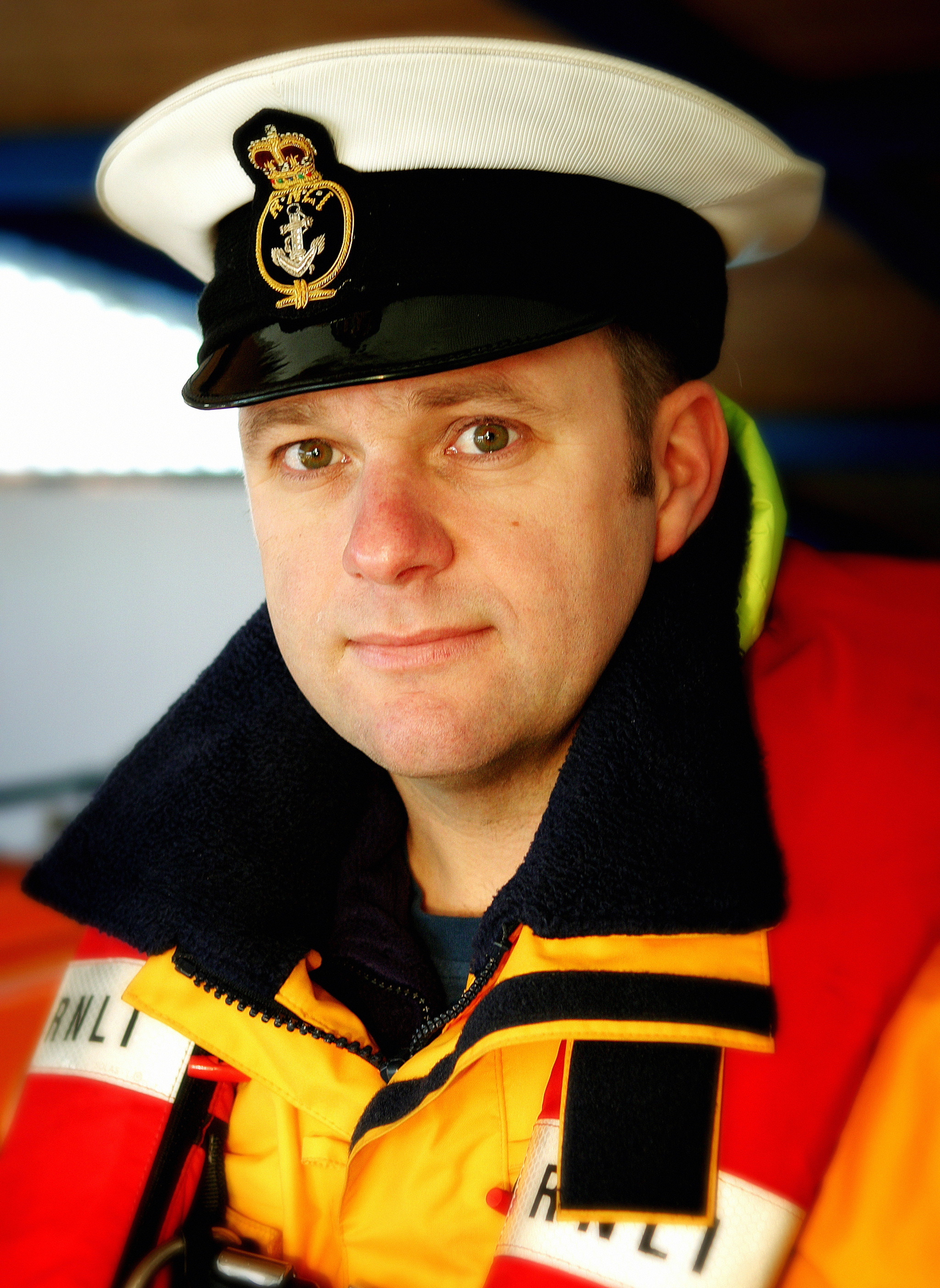 a lifeboat man in life jacket and cap