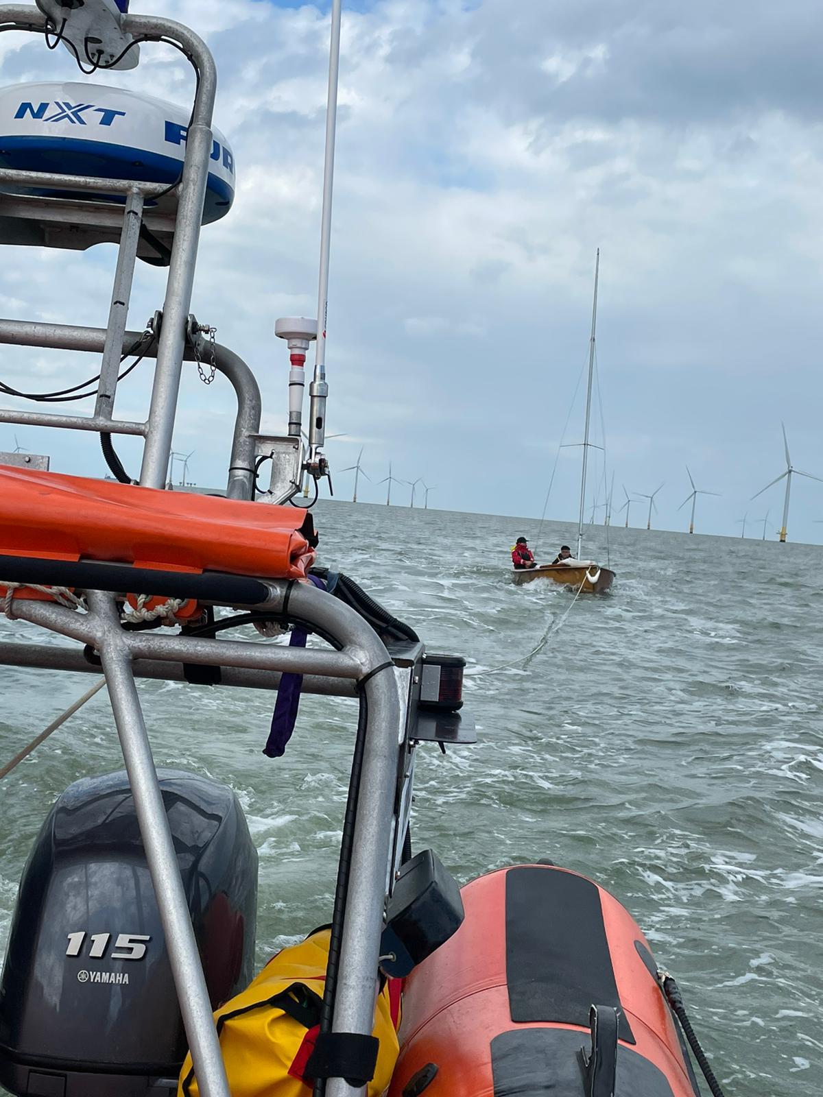 The sailing dinghy under tow.