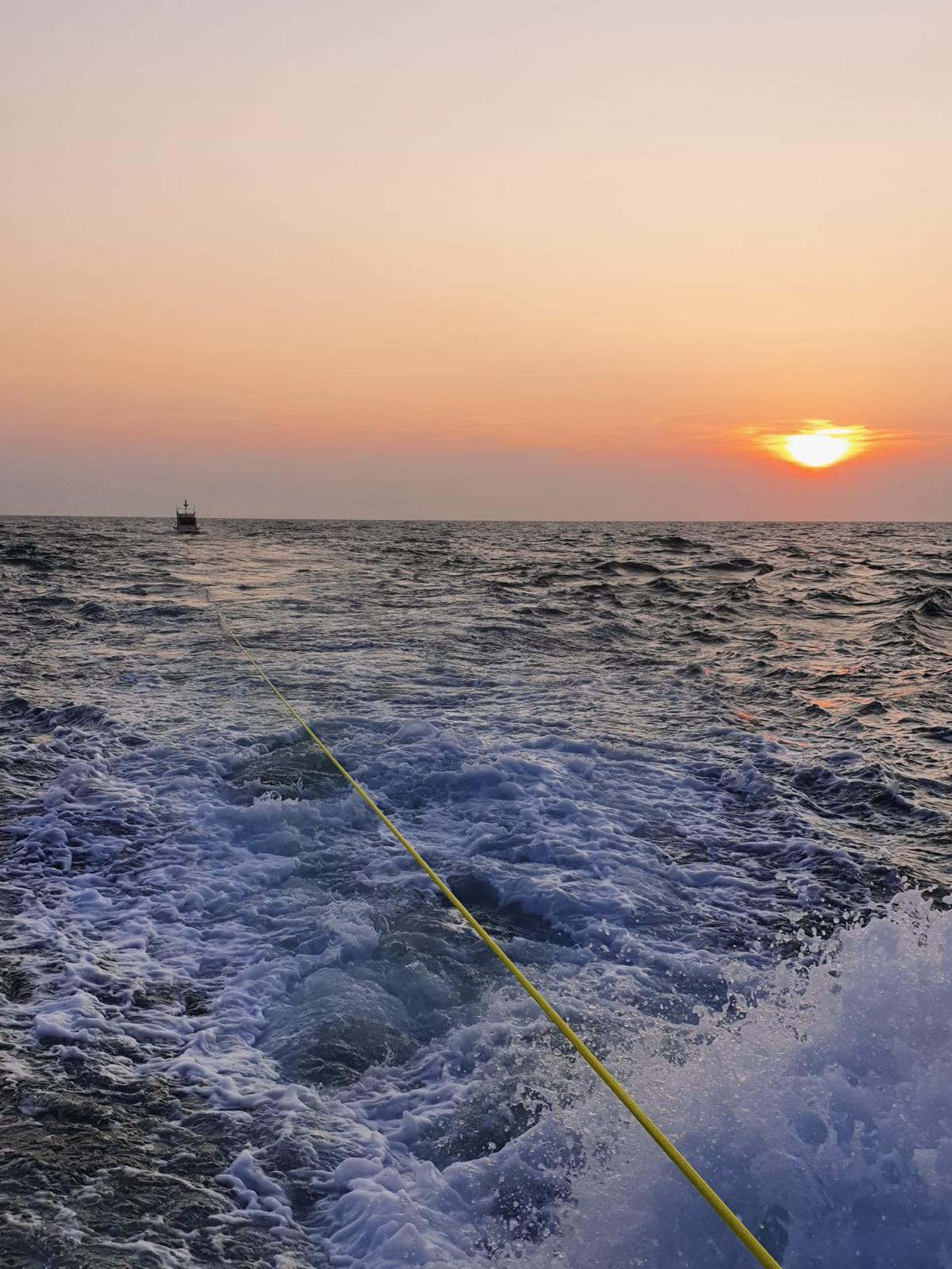 Sun setting as RNLI Wells all-weather lifeboat tows disabled cruiser to Wells harbour
