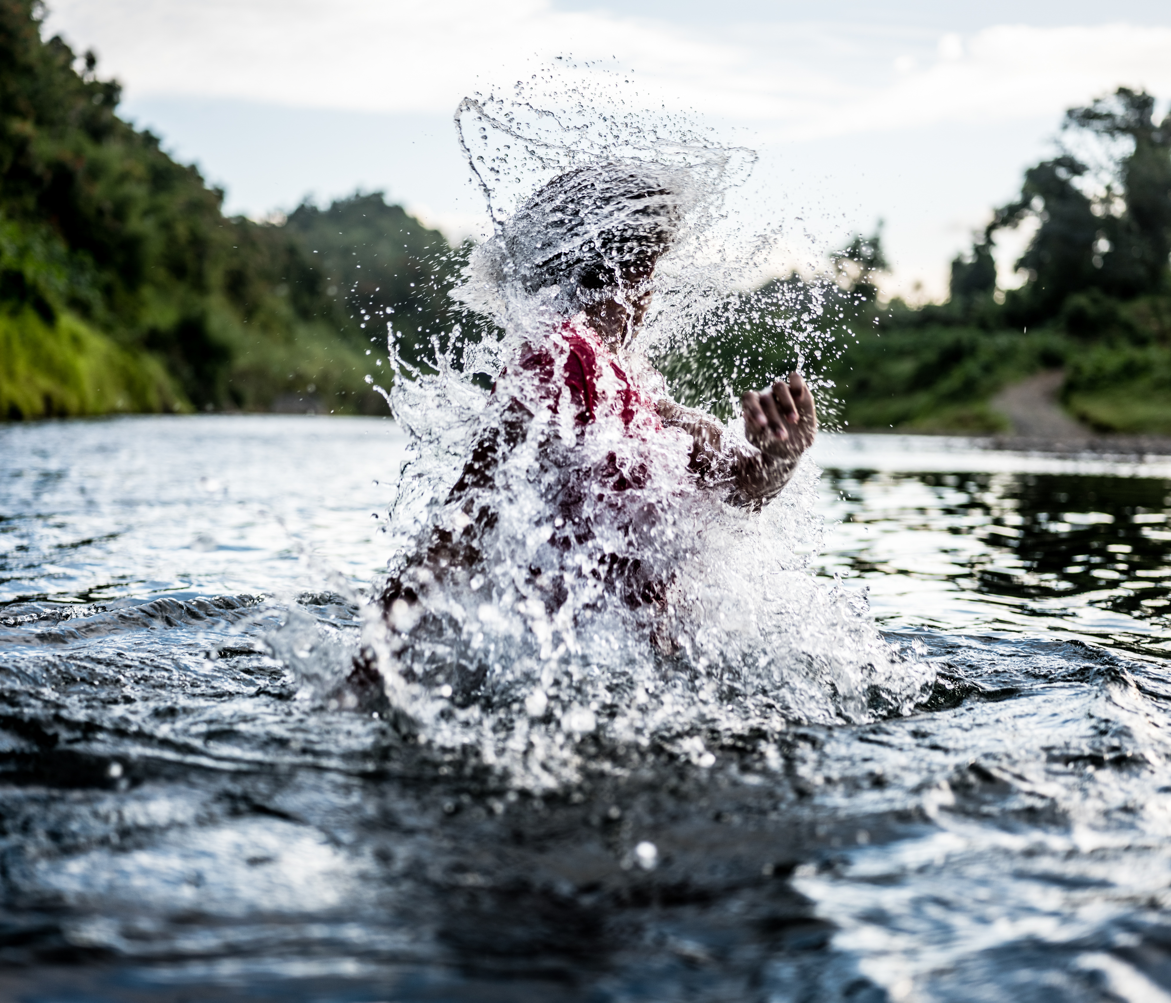 A small girl plays in a river