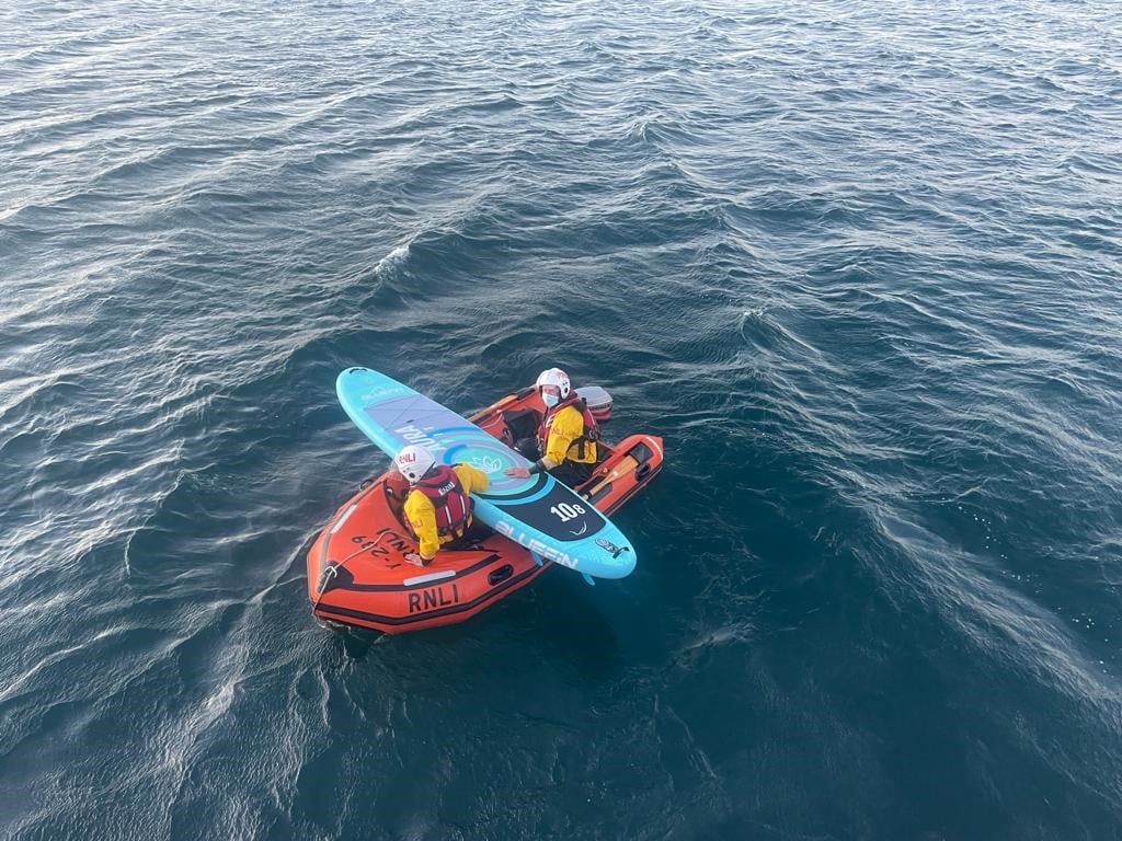 Porthdinllaen crew members recover the paddleboard