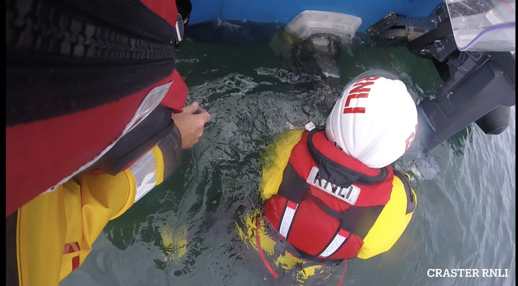 A volunteer crew member in the water undoing the fouled rope from propeller 