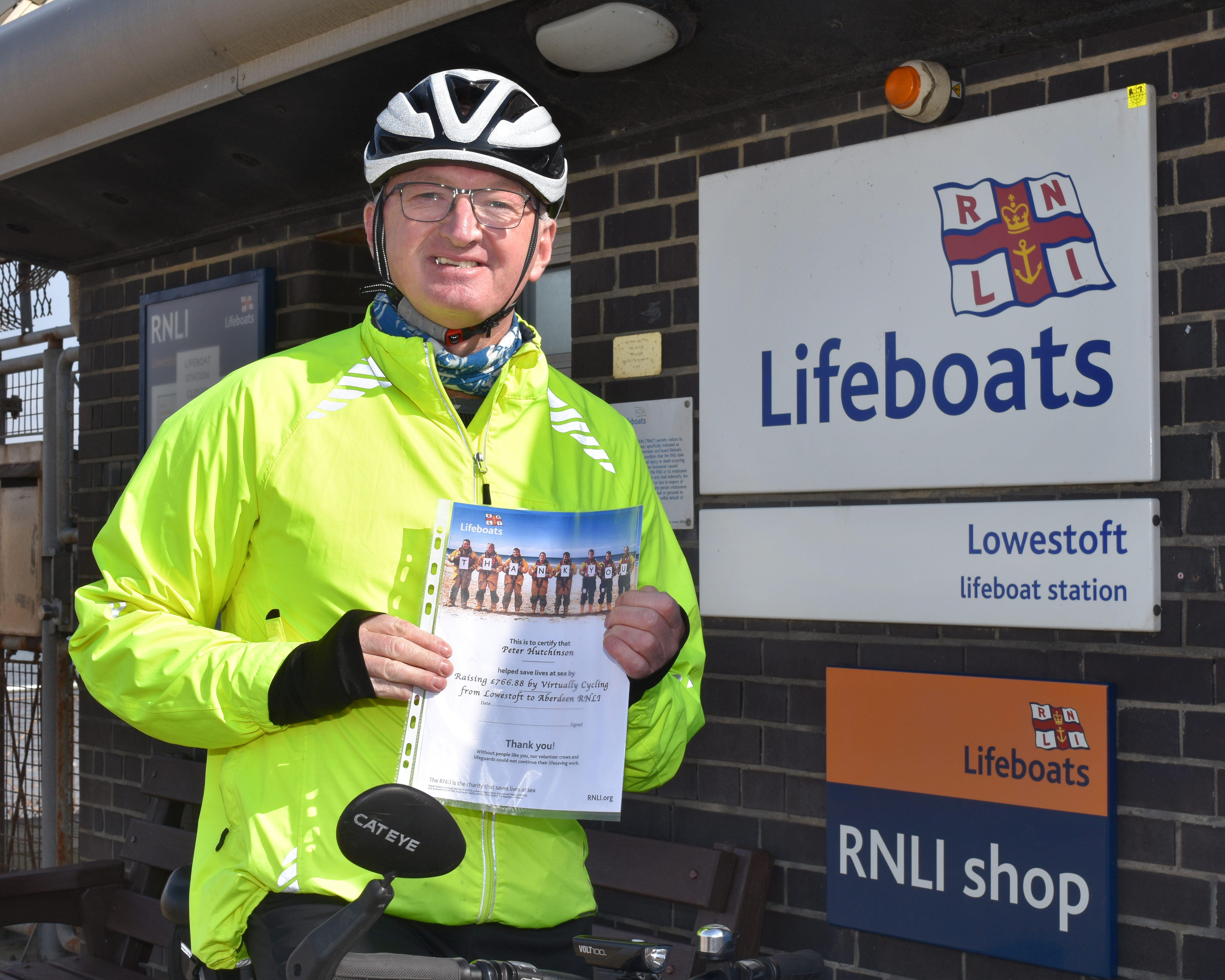 Fundraising cyclist Peter Hutchinson with a certificate of thanks for completing a virtual 575 mile challenge