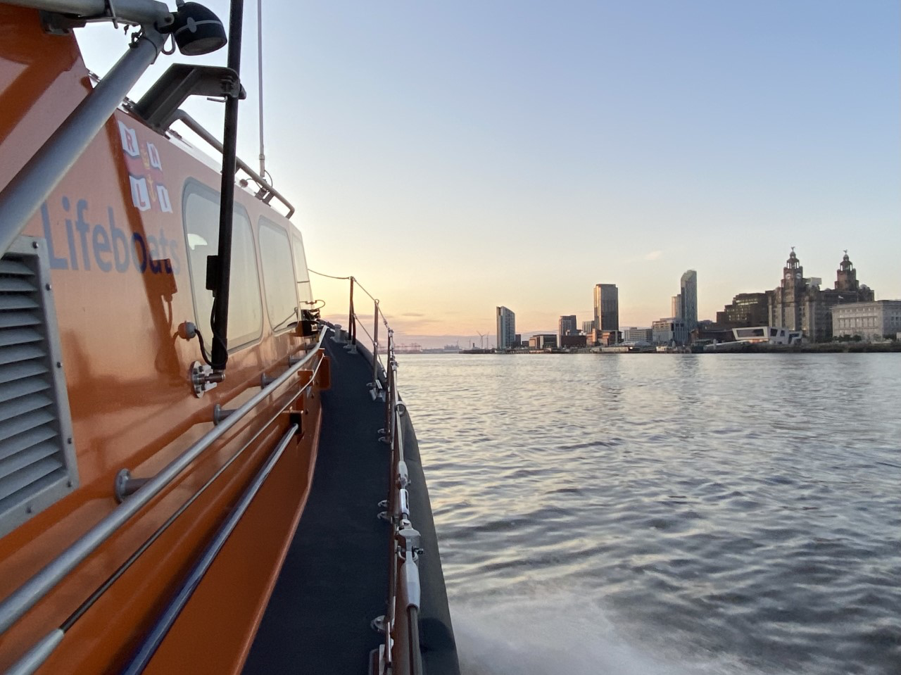 RNLI Hoylake lifeboat is stood down and exits the River Mersey at sunset