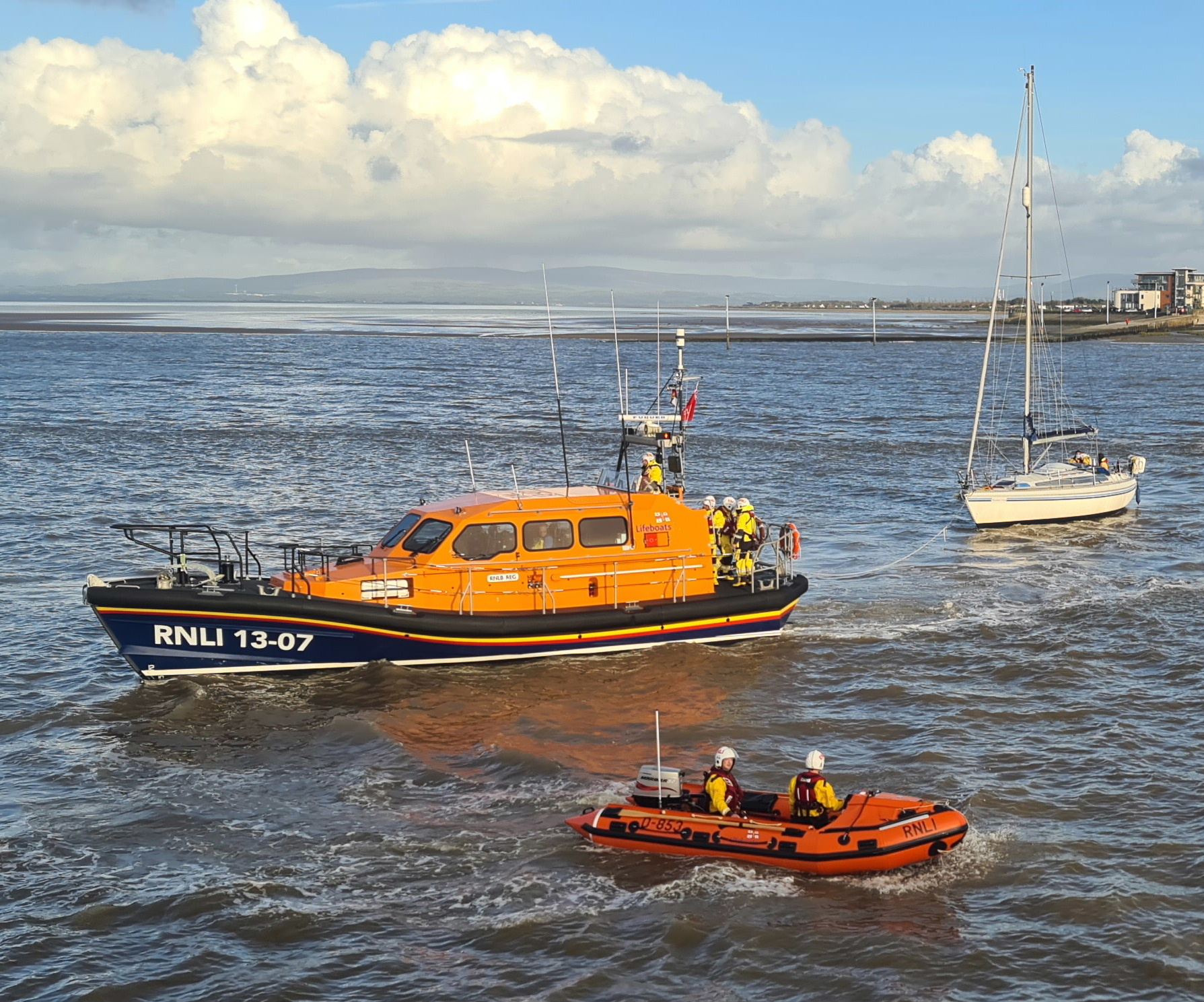 a Lifeboat and Inshore Lifeboat attend to a yacht