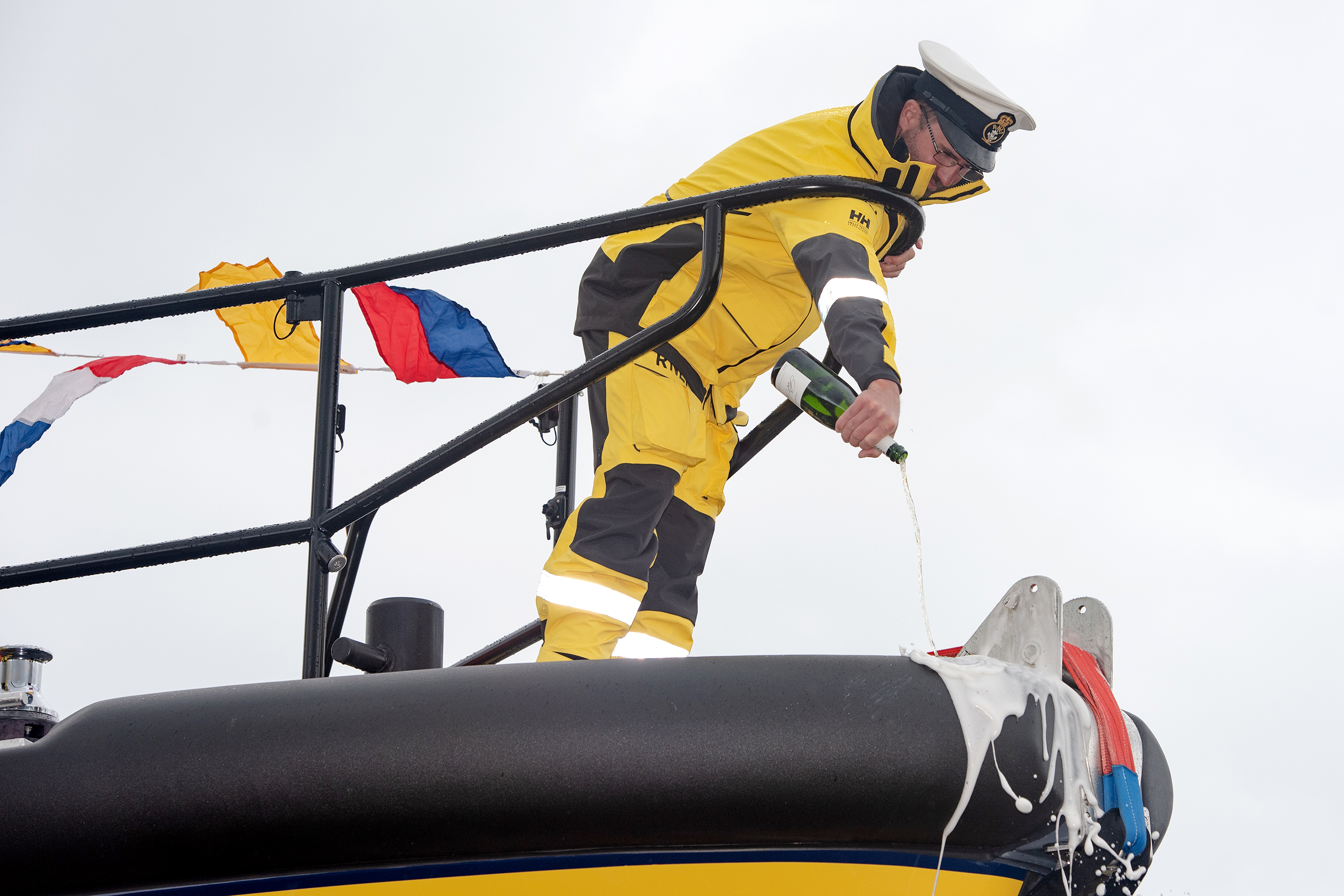 Staff Coxswain Peter Hanscombe pouring champagne over the bow of the all-weather lifeboat during the naming ceremony.
