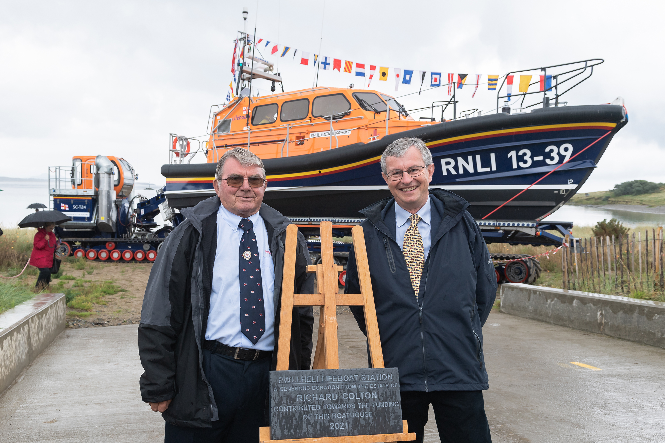 Pwllheli RNLI Chair Alan Jones and Charles Denton, Godson and executor of the Richard Colton Estate unveiling a plaque to officially open Pwllheli's new RNLI boathouse.