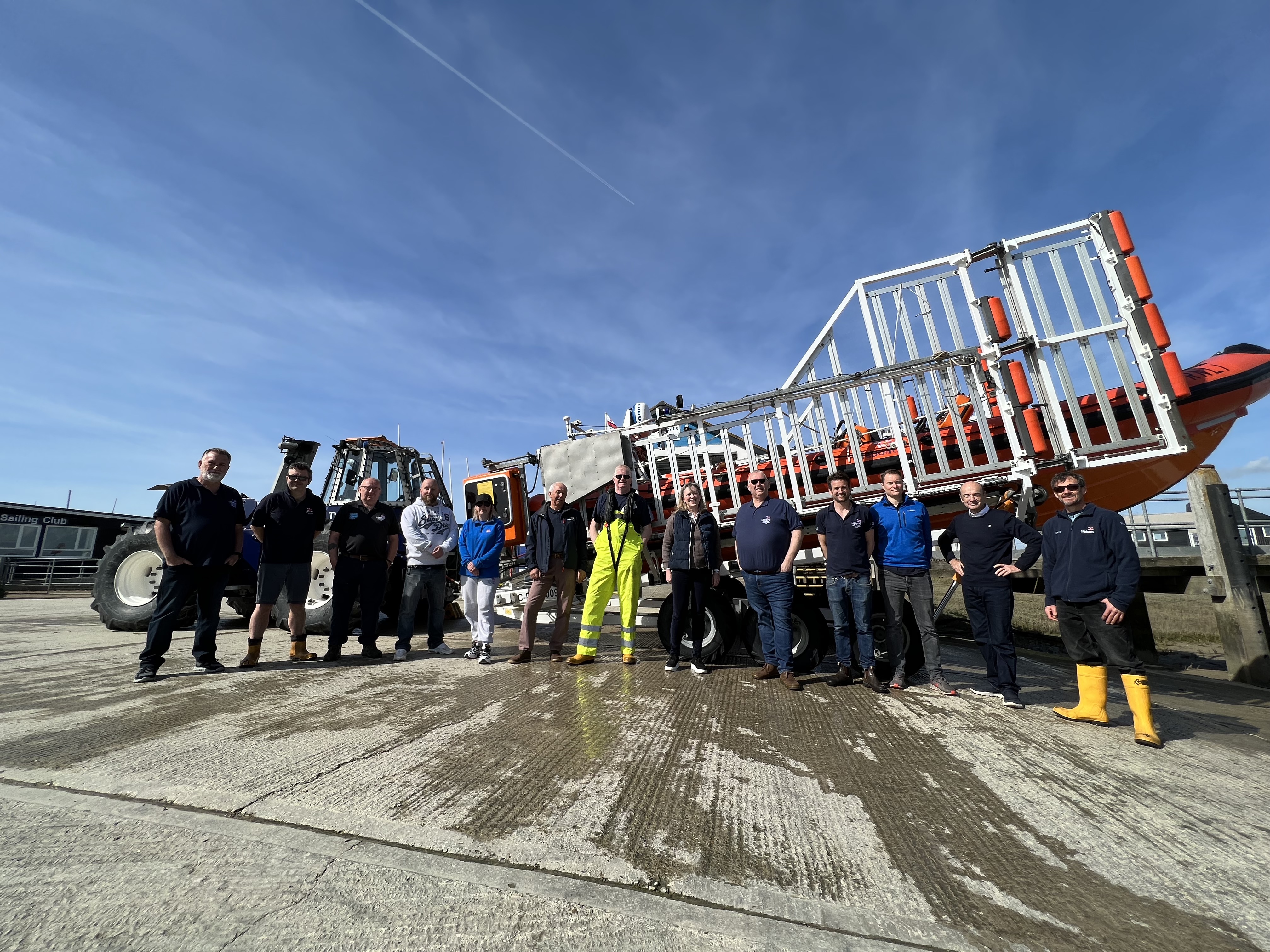 Sally-Ann Hart and lifeboat station volunteers standing in front of the lifeboat and tractor