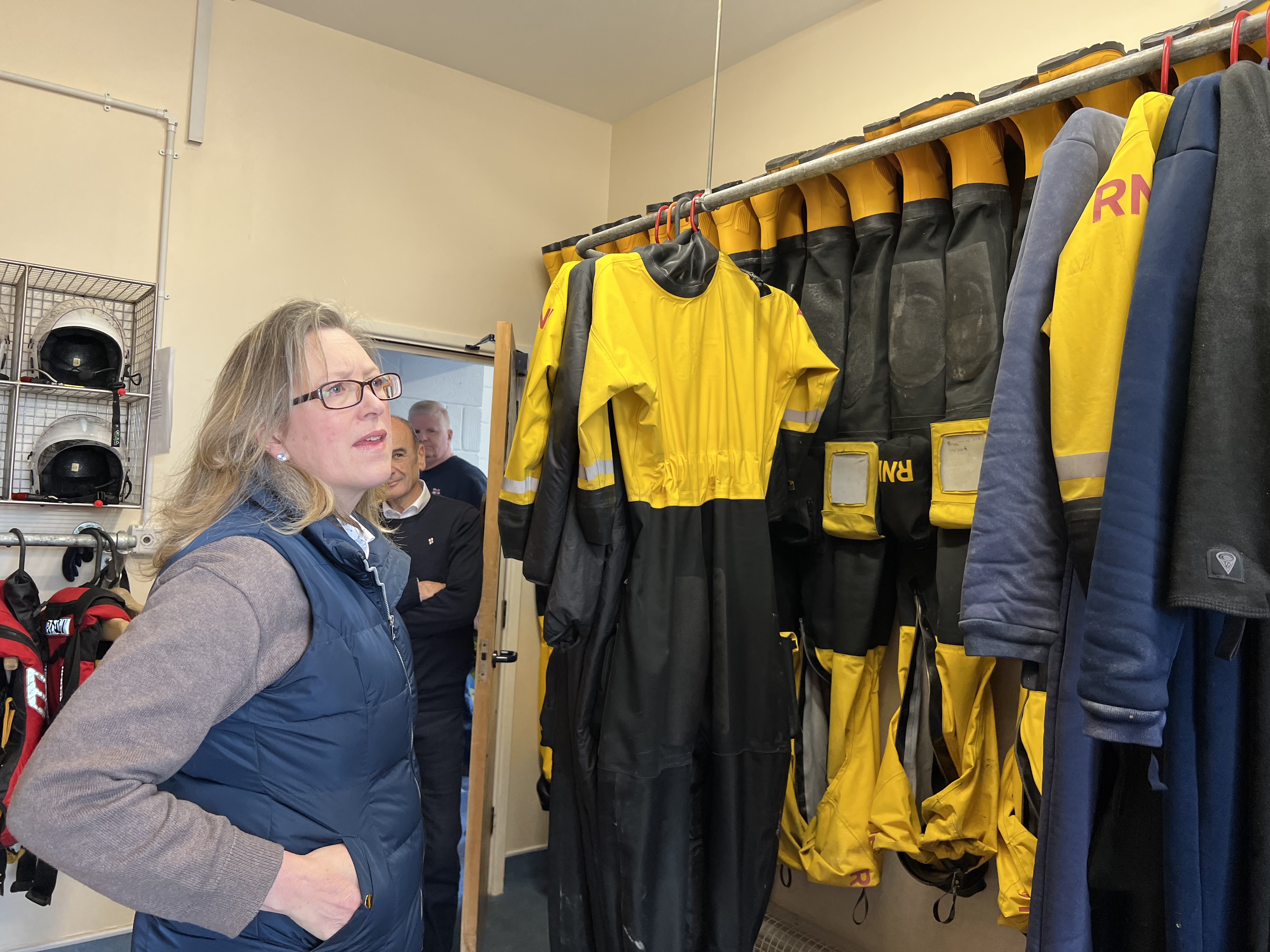 In the crew changing room Sally-Ann Hart stands in front of the rack on which boat crew PPE is drying