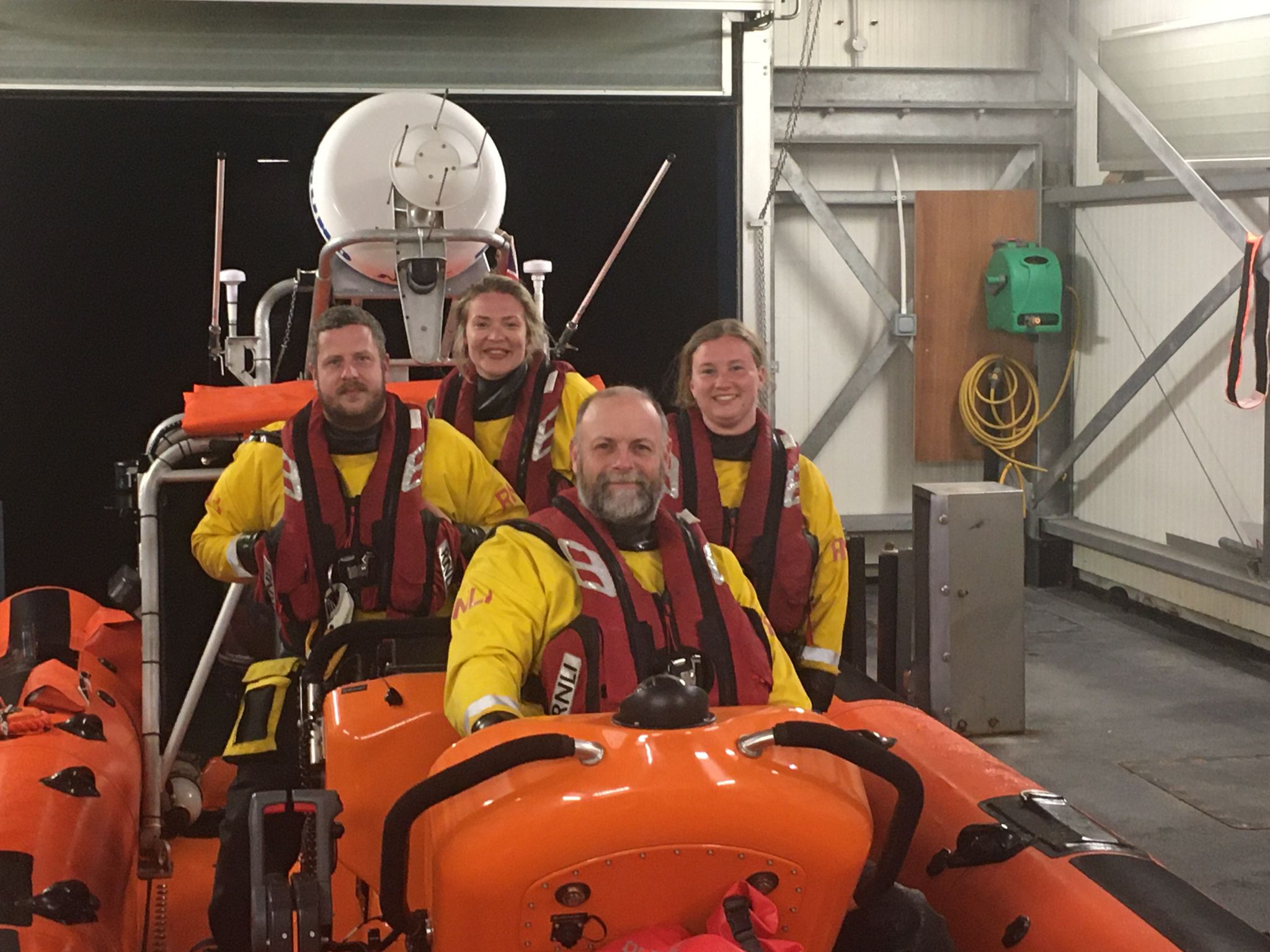 Four crew members sat on a lifeboat
