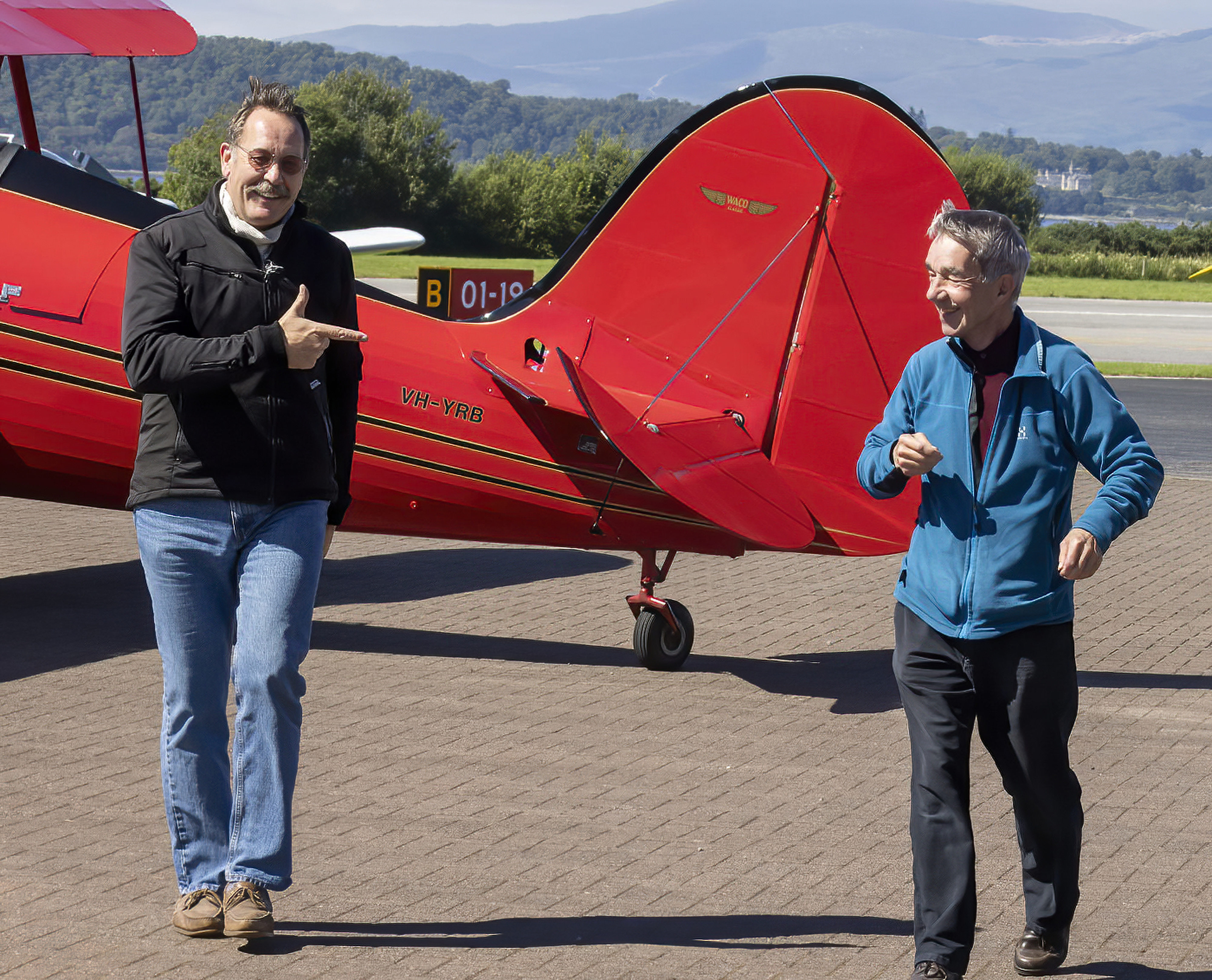 Archie and David smile as they walk away from the aircraft