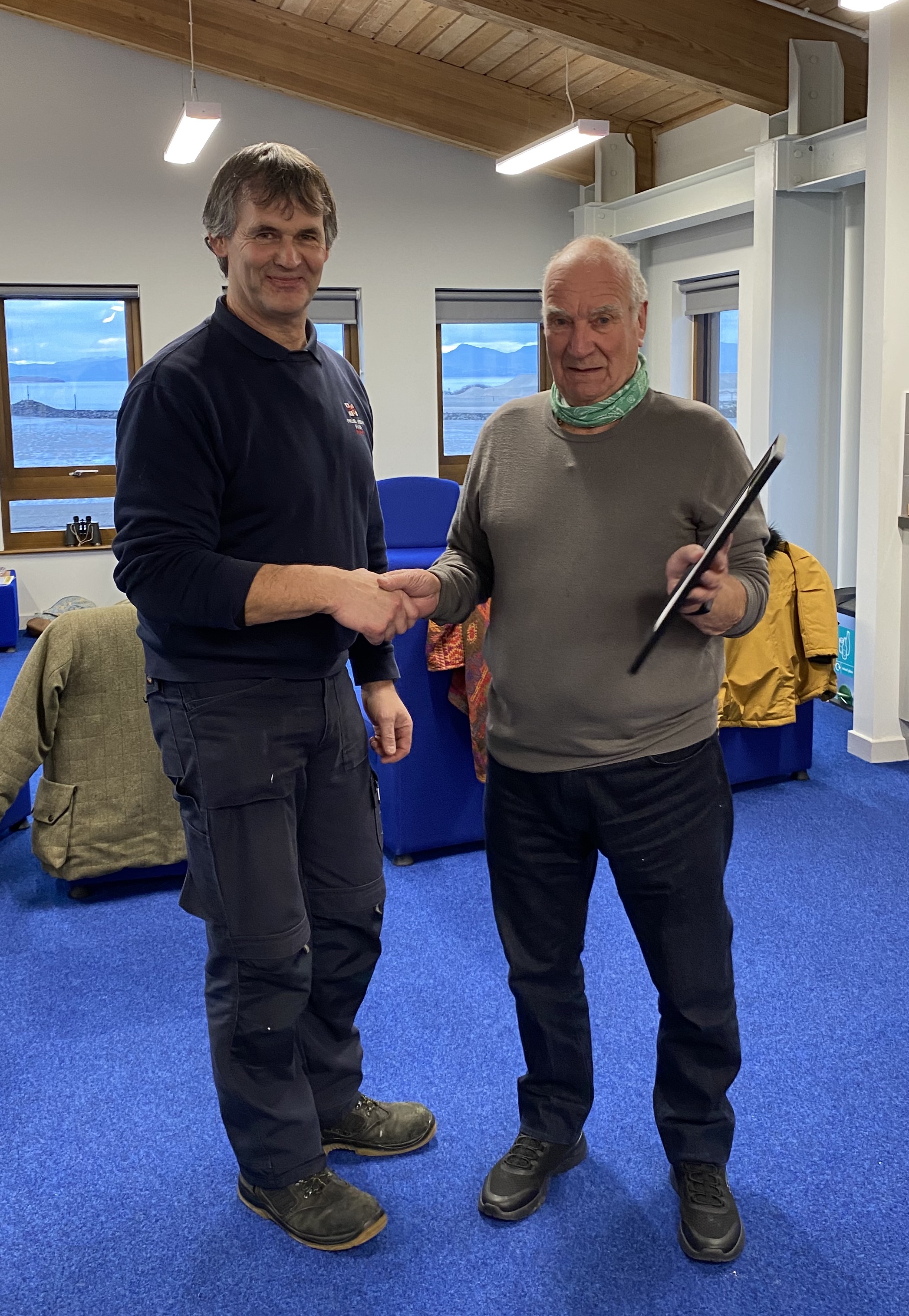 Pwllheli RNLI mechanic Alwyn Roberts on the left of the photohand shaking hands with Bernard