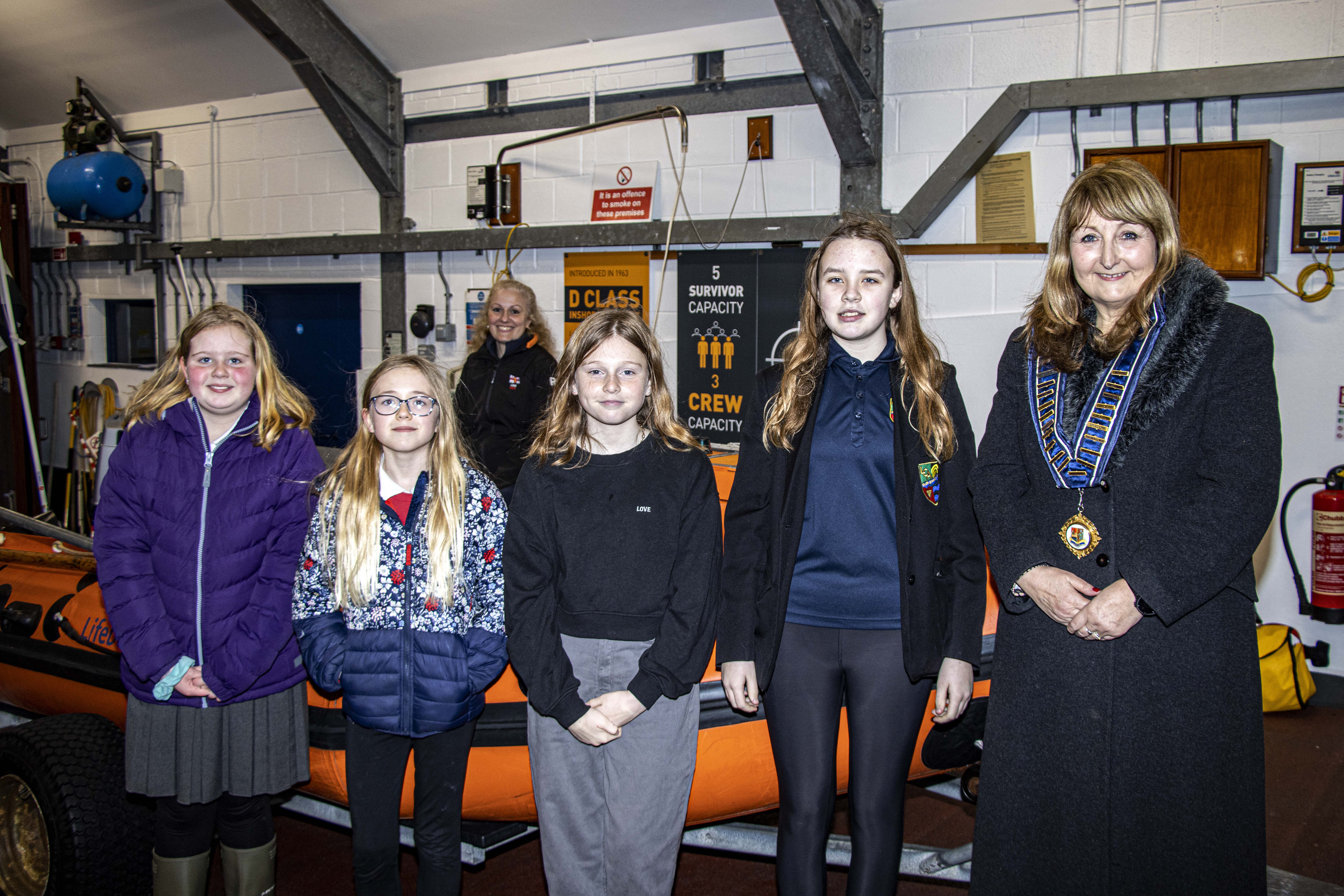 Bookmark winners at Looe Lifeboat Station Left to right Paige, Sophie, Evie, Lowenna and Deputy Mayor Edwina Hannaford with Looe RNLI volunteer crew Victoria Thomas in the background
