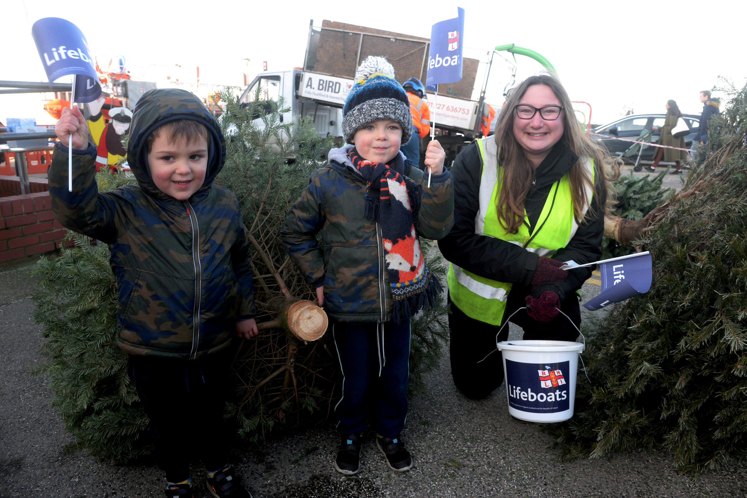 Freddie, three and Harry Lawson, five hand over theeir Christmas tree to Crewmember Ruth Oliver at Whitstable Lifeboat Station on Sunday morning.