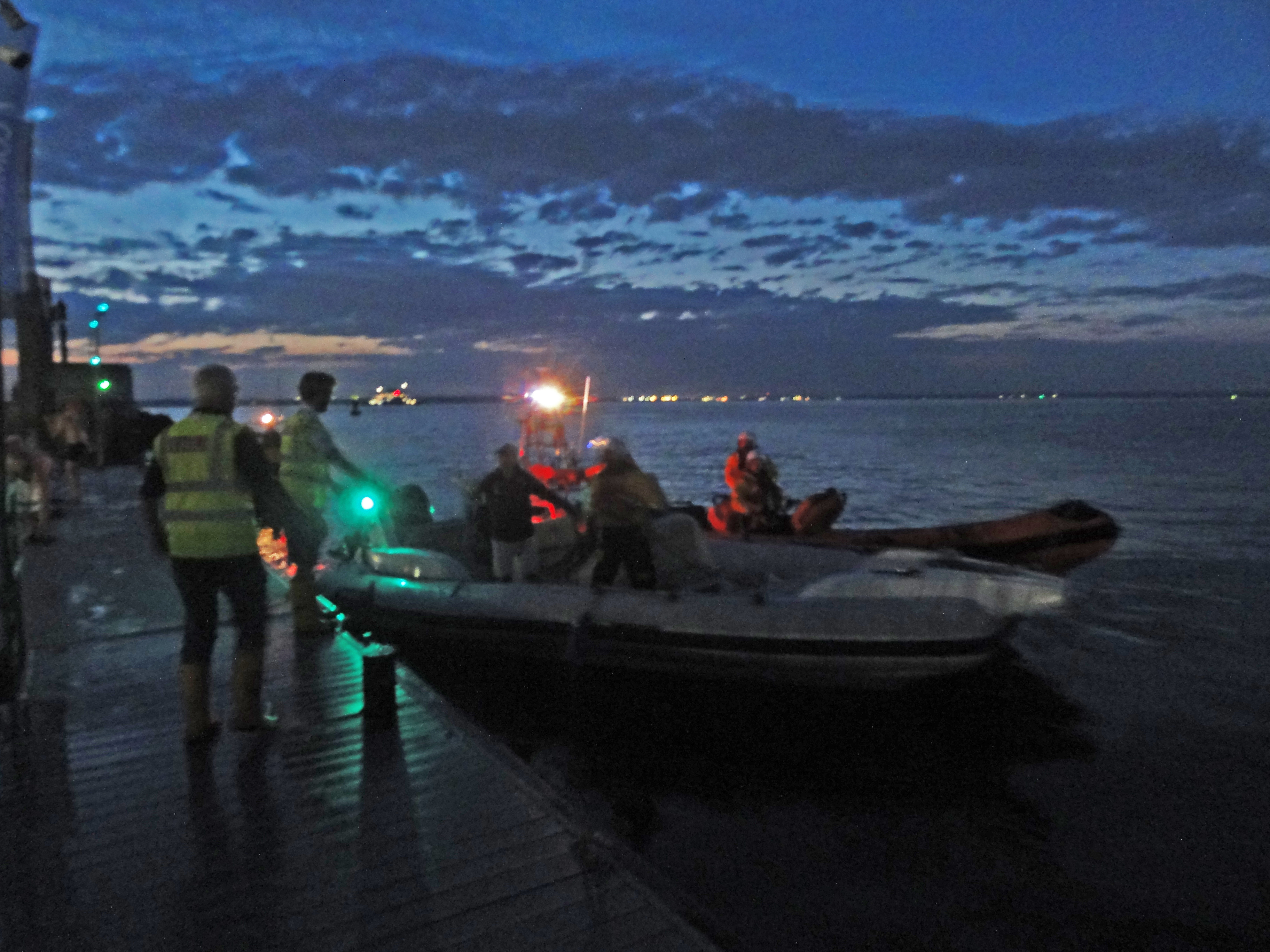 Photo in semi-darkness of the RIB being brought alongside Trinity Landing.