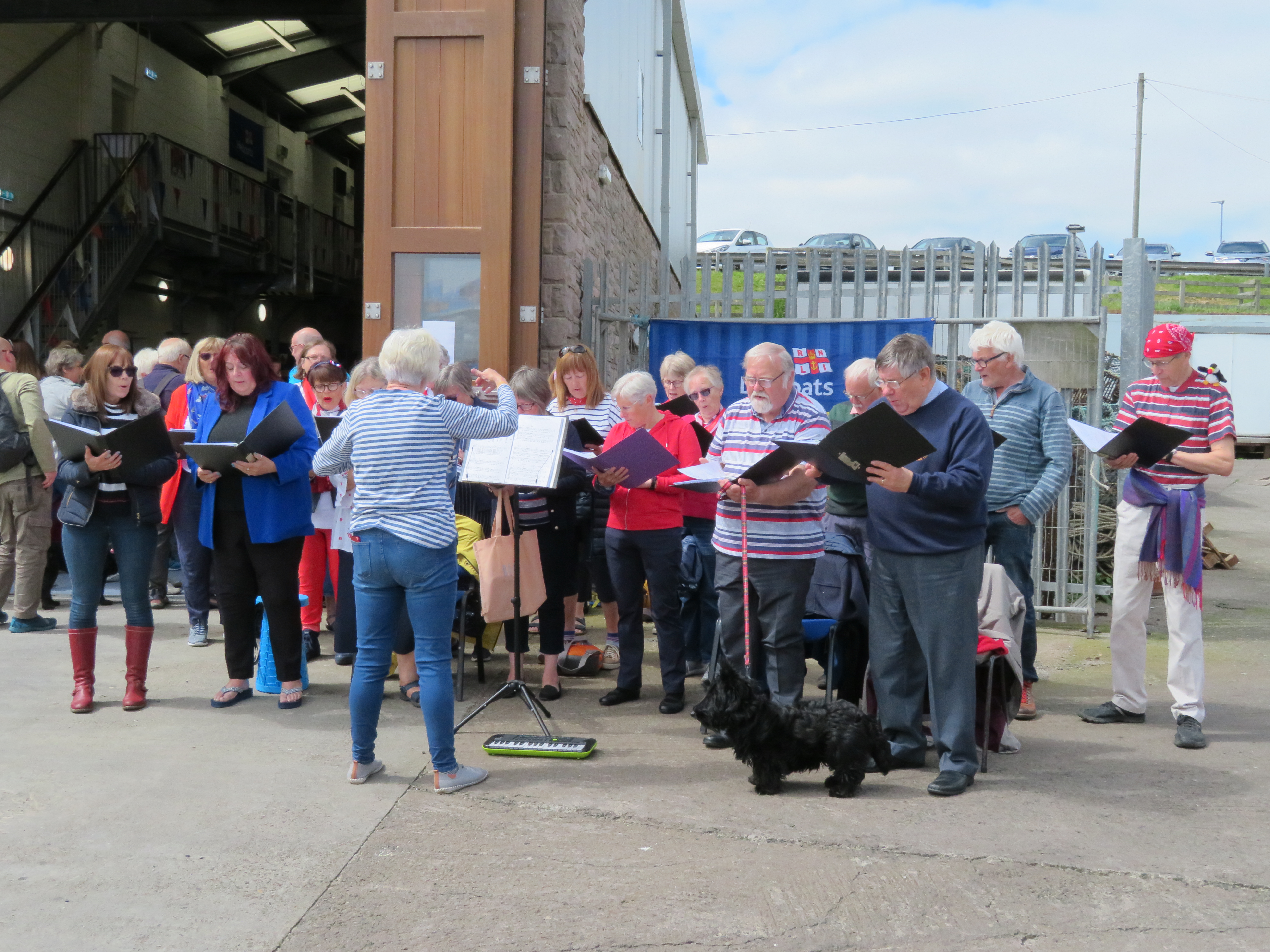 Seahouses Village Voices perform outside the boathouse
