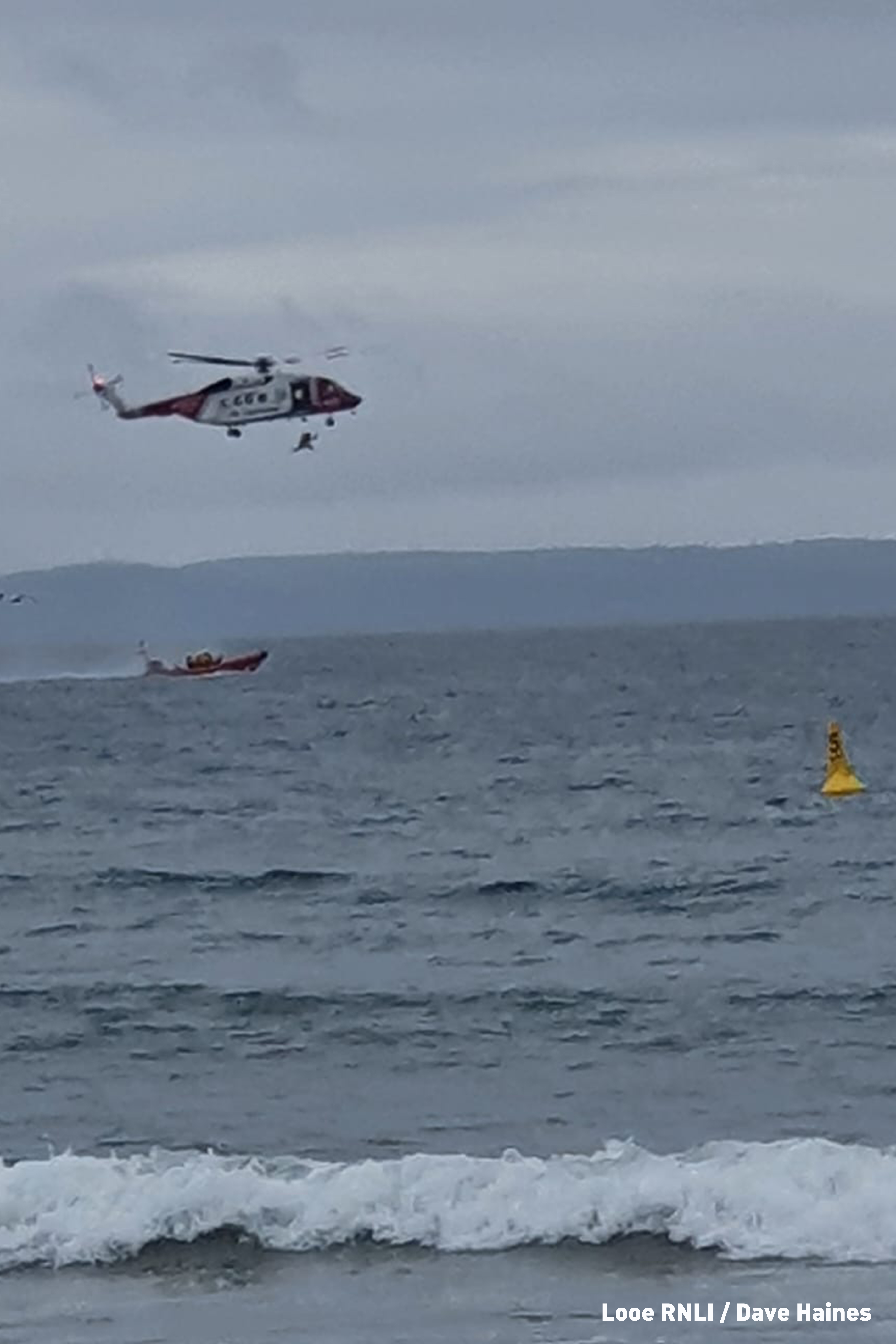 Rescue 924 paramedic winching down to Looe RNLI Atlantic 85 Sheila and Dennis Tongue II
