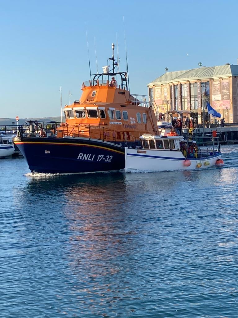 RNLI All-Weather Lifeboat reurning to Weymouth Harbour with broken down fishing vessel