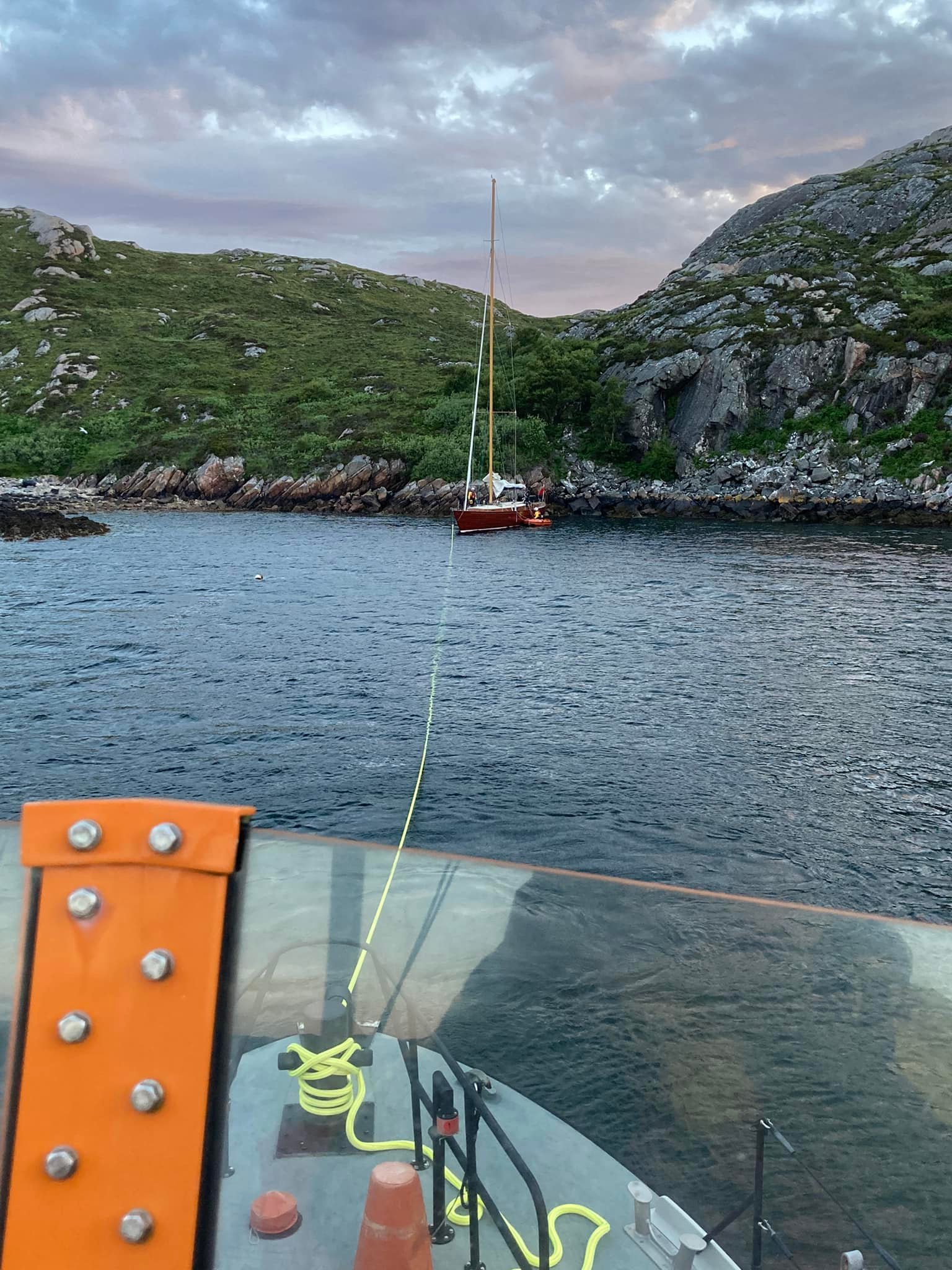 The RNLI Lochinver lifeboat can be seen towing the casualty vessel to safety