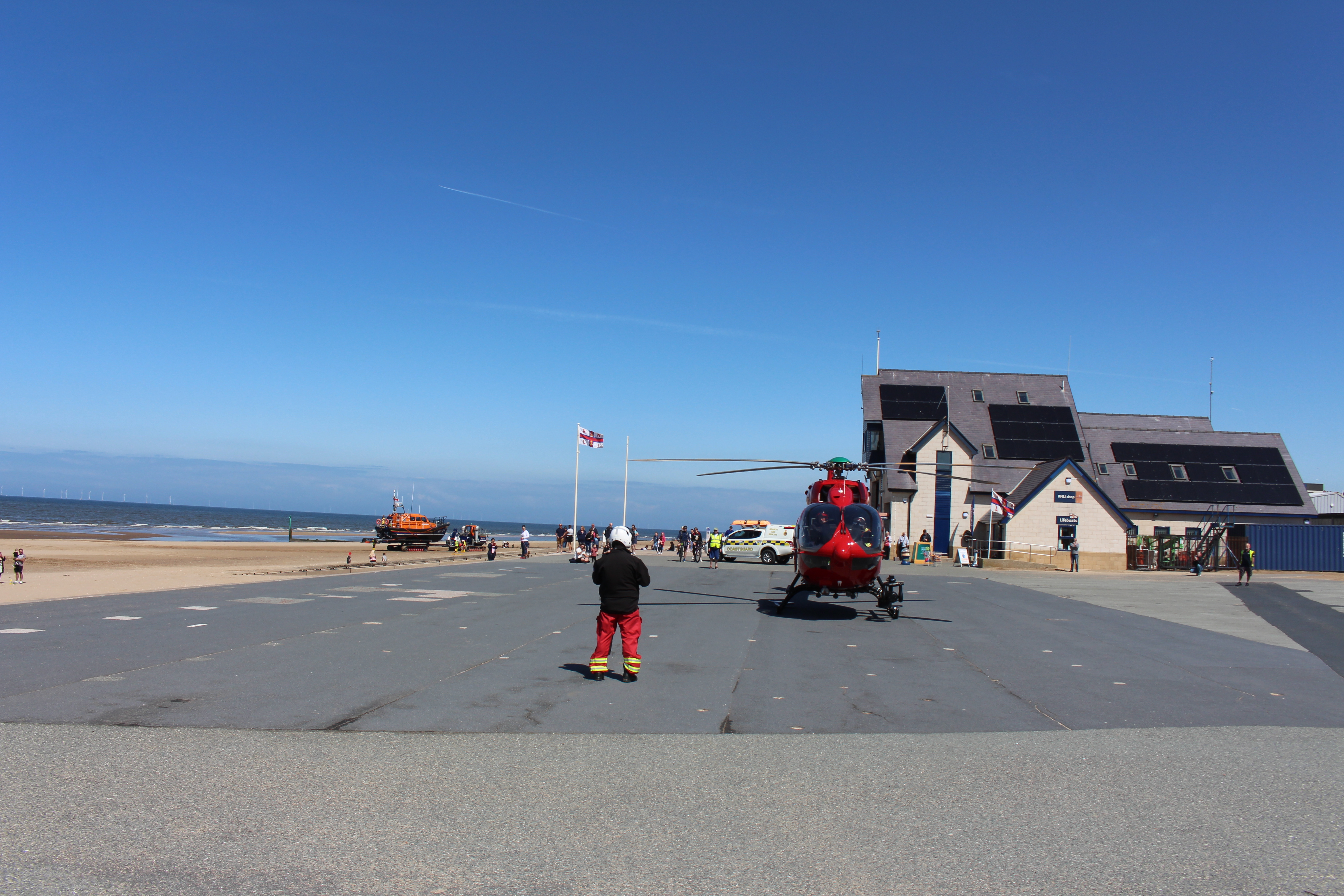 Rhyl lifeboat being recovered with air ambulance in foreground