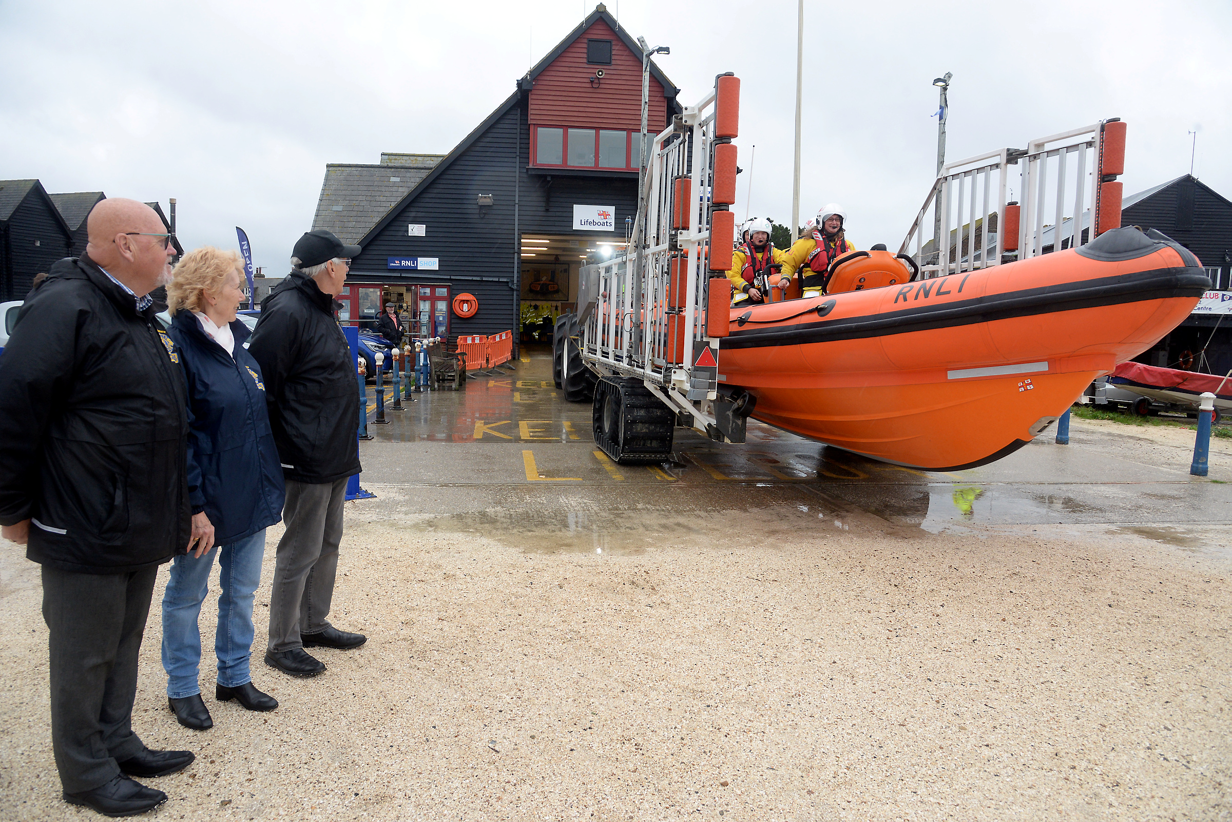 Whitstable &amp; Herne Bay Lions Club Past President Eddie Warn, Treasuer Fiona Page and President Geoff Lindley watch the lifeboat launch on exercise after the cheque presentation held at the boathouse on Sunday. Picture: RNLI Whitstable.