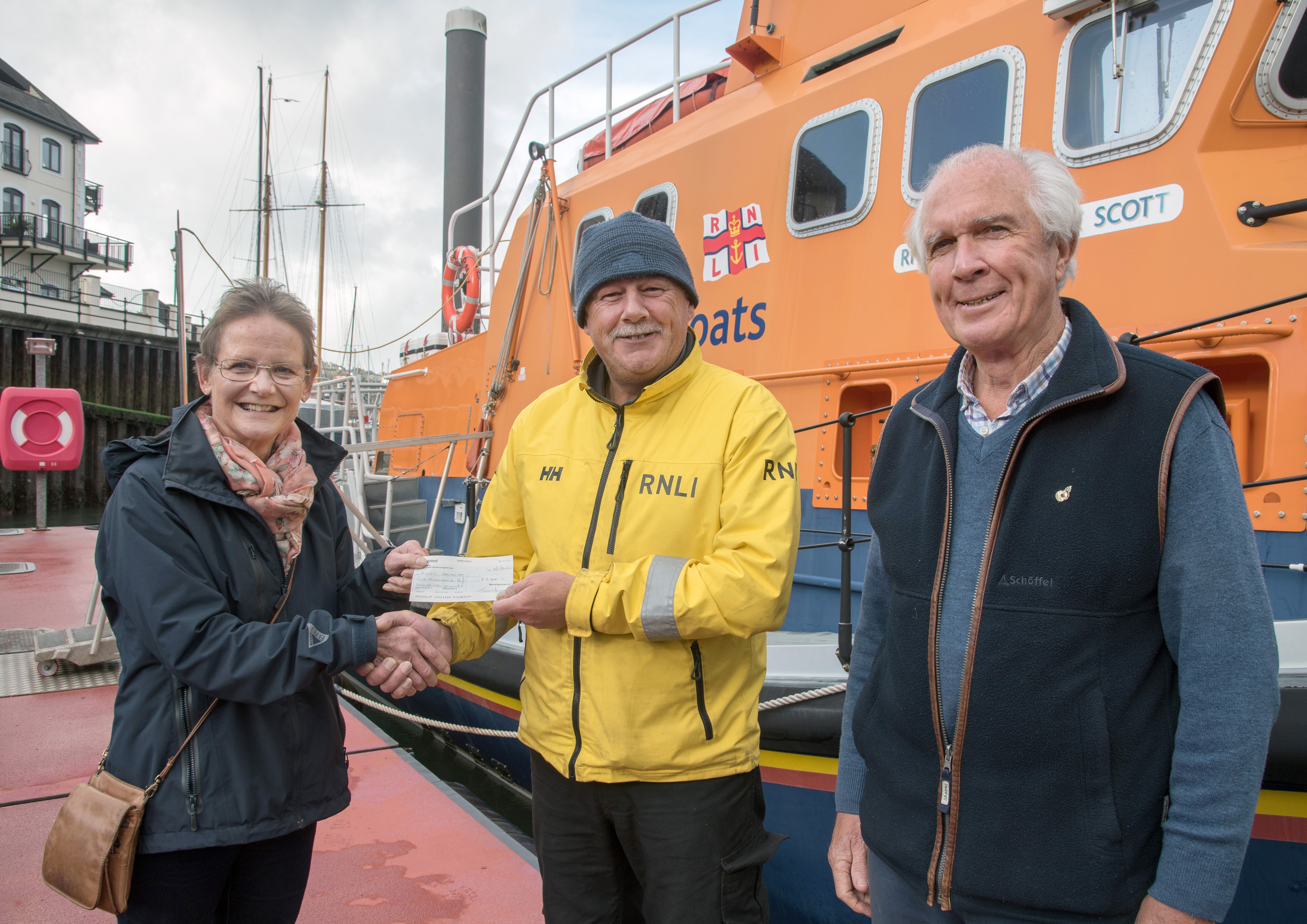Tina Walker presenting the cheque to Falmouth RNLI Coxswain Jonathon Blakeston and Martin Winters.
