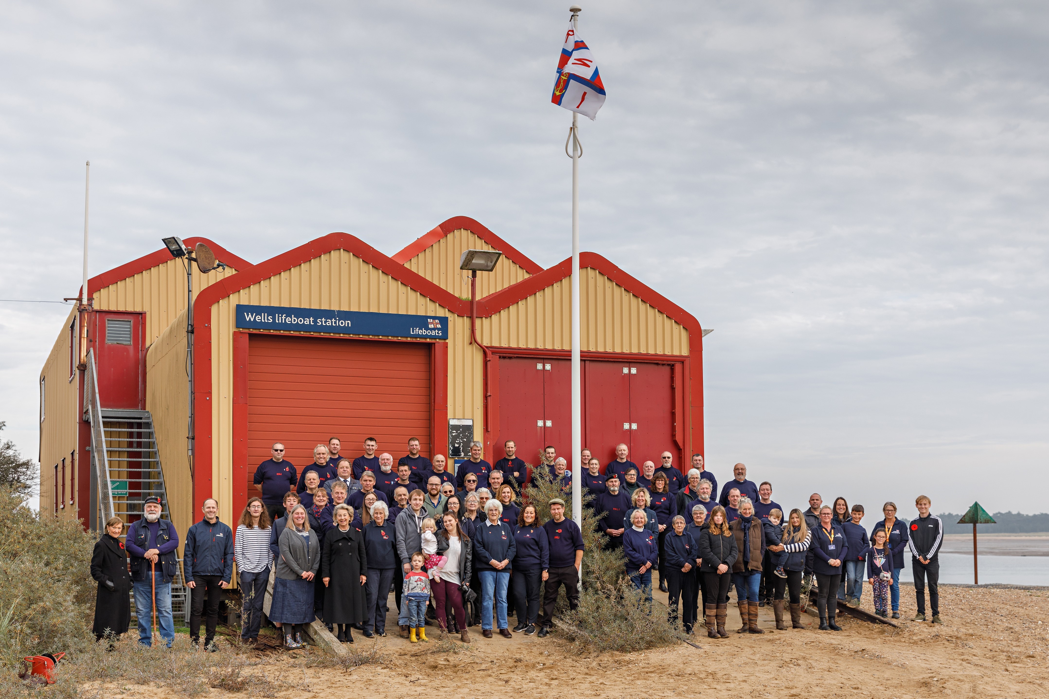 The crew and wider lifeboat family enjoy the flag ceremony which began at the old lifeboat station